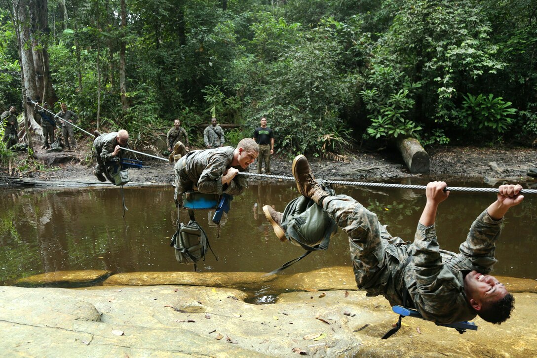 U.S. soldiers maneuver across a wire cable over a river during a team obstacle course event at the French jungle warfare school in Gabon, June 10, 2016. Army photo by Spc. Yvette Zabala-Garriga 