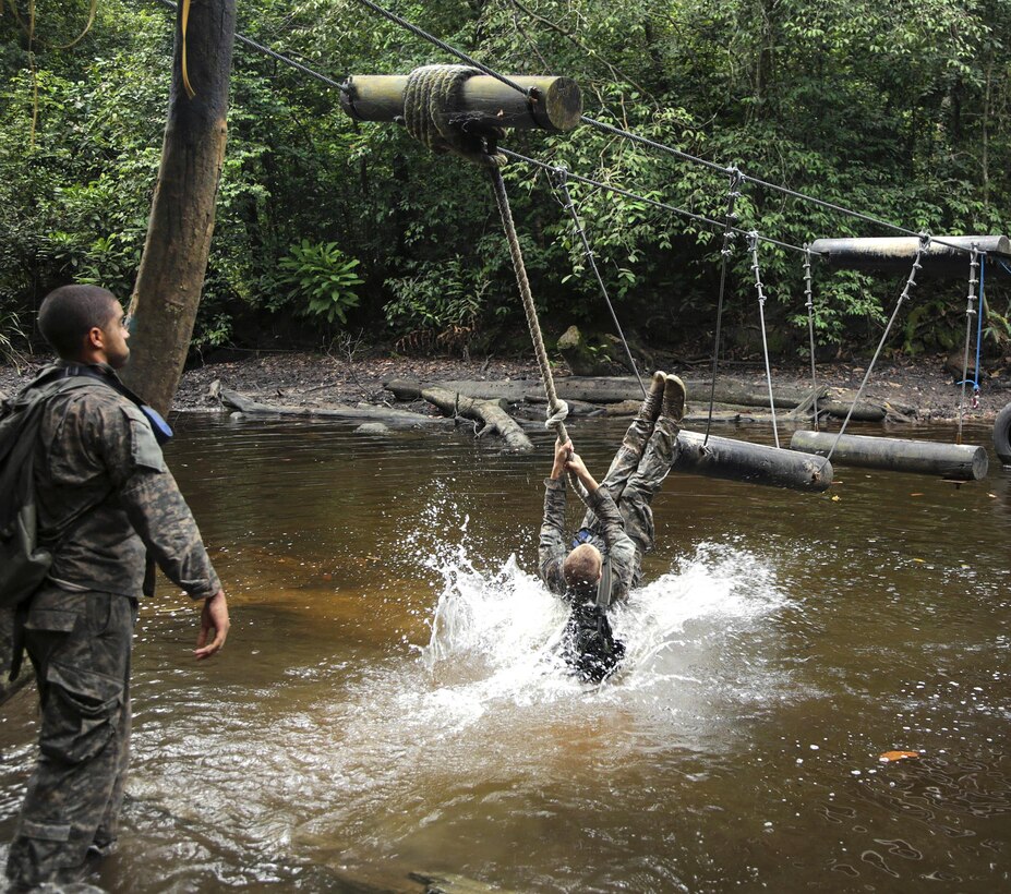 A U.S. soldier swings onto a log during a team obstacle course event at the French jungle warfare school in Gabon, June 10, 2016. Army photo by Spc. Yvette Zabala-Garriga