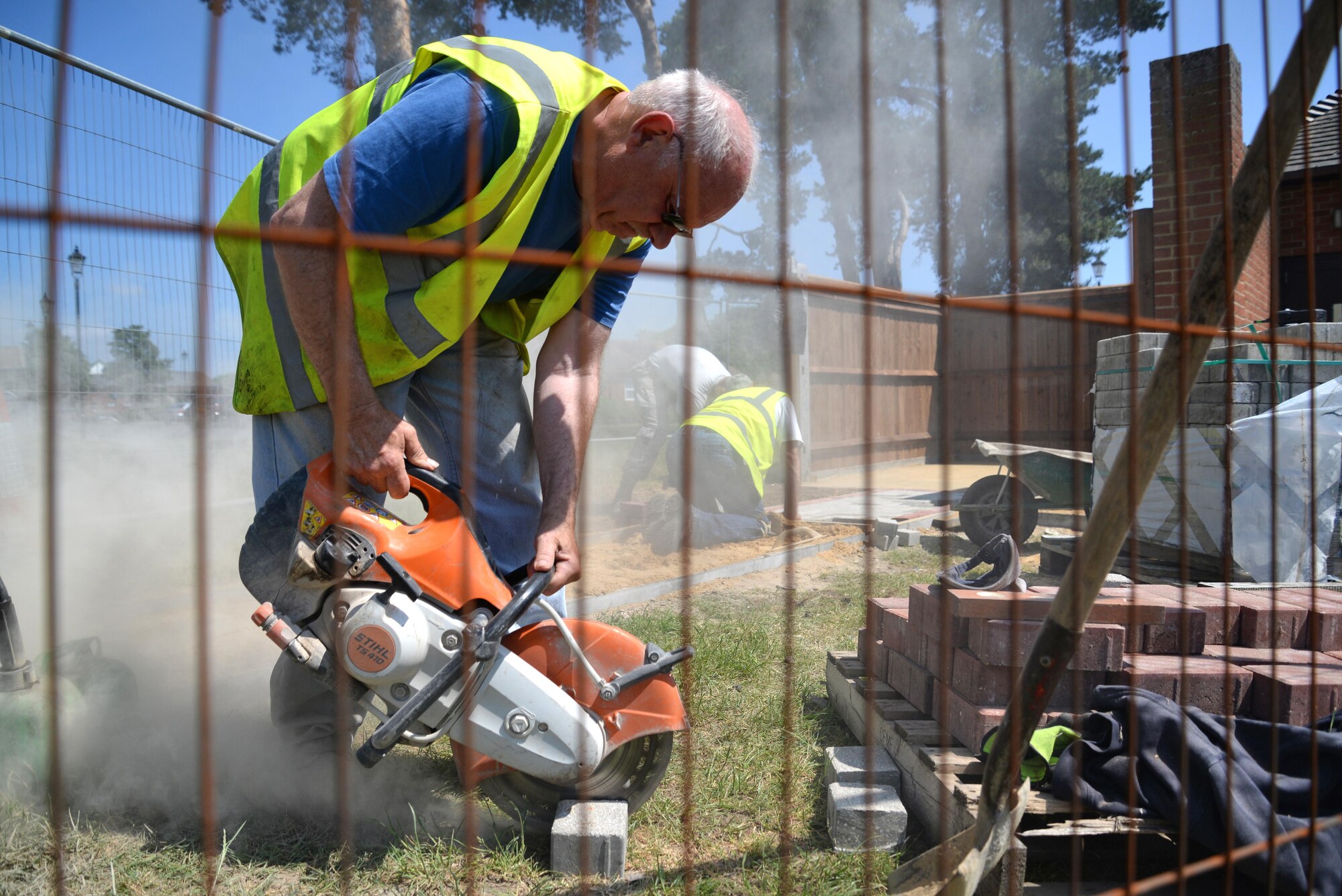 Graham Thornton, 100th Civil Engineer Squadron Horizontal Pavement and Construction Equipment operator, cuts a stone brick June 9, 2016, on RAF Mildenhall, England. The 100th CES Horizontal Pavement and Construction Equipment shop has three civilians that work alongside the Airmen. (U.S. Air Force photo by Senior Airman Christine Halan/Released)