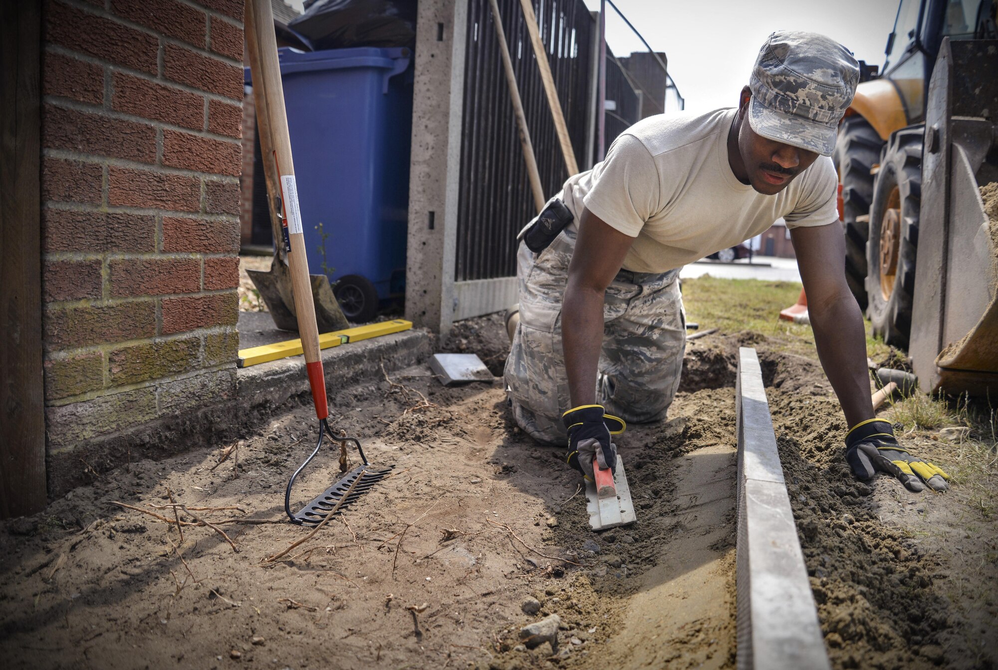 U.S. Air Force Senior Airman Dishawn Harvey, 100th Civil Engineer Squadron Horizontal Pavement and Construction Equipment operator, smooths out cement mixture June 8, 2016, on RAF Mildenhall, England. The 100th CES Horizontal Pavement and Construction Equipment has eight Airmen and civilians who work together on a wide variety of projects around base. (U.S. Air Force photo by Senior Airman Christine Halan/Released)