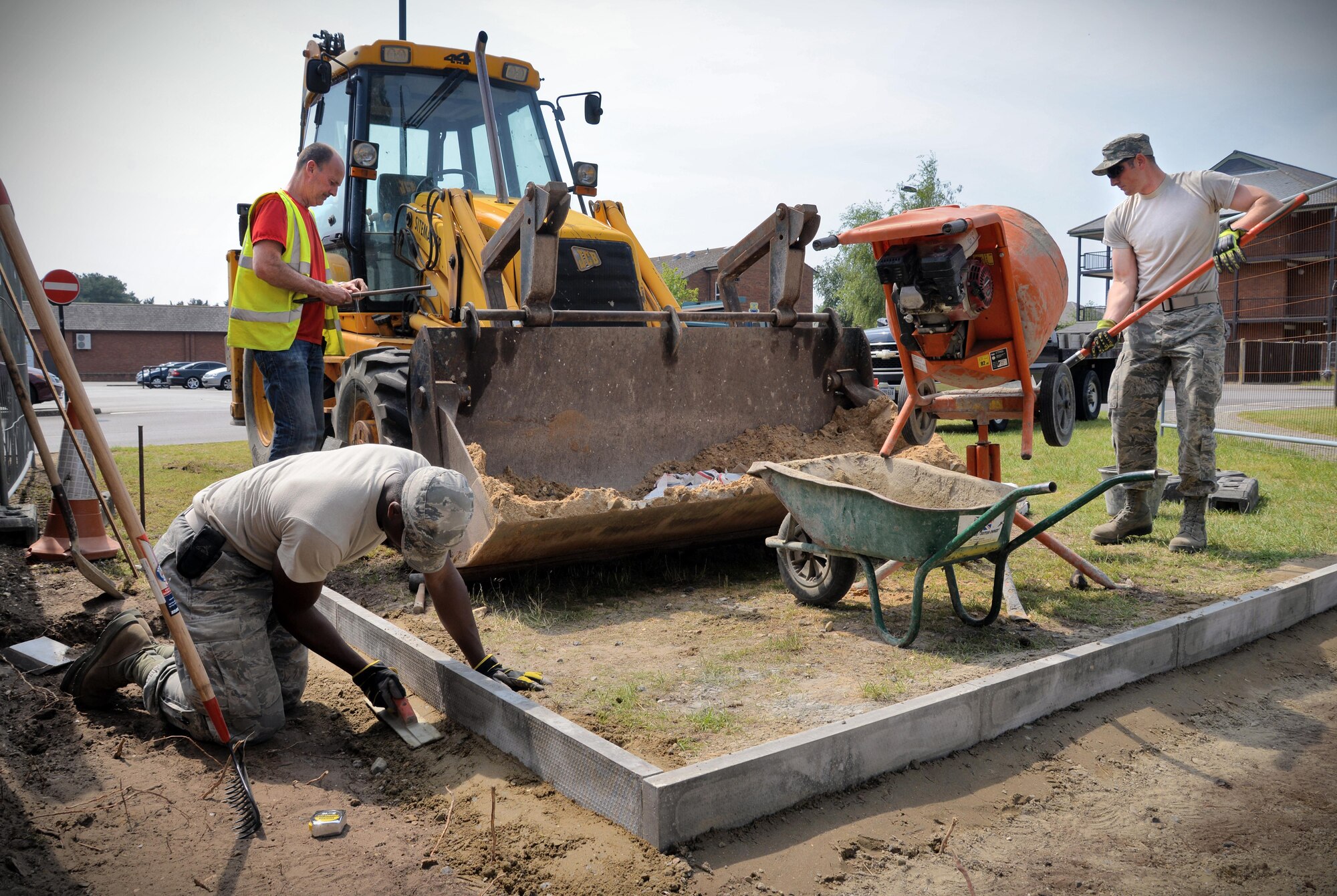 Members from the 100th Civil Engineer Squadron Horizontal Pavement and Construction Equipment shop work on creating a sidewalk June 8, 2016, on RAF Mildenhall, England. Airmen and civilians work all over base working on anything from fencing around the flightline to the flightline itself. (U.S. Air Force photo by Senior Airman Christine Halan/Released)