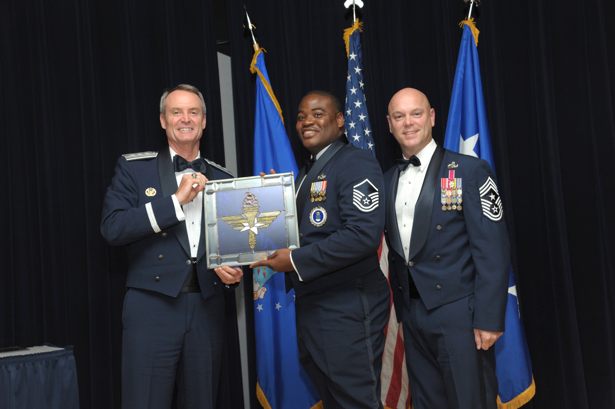 Master Sgt. Eric Hart, 344th Recruiting Squadron, Waco, Texas, receives an award from Lt. Gen. Darryl Roberson, commander, Air Education and Training Command and AETC Command Chief Master Sgt. David Staton during a ceremony here, June 16. Hart was selected as the AETC Recruiter of the Year. (U.S. Air Force photo by Joel Martinez)