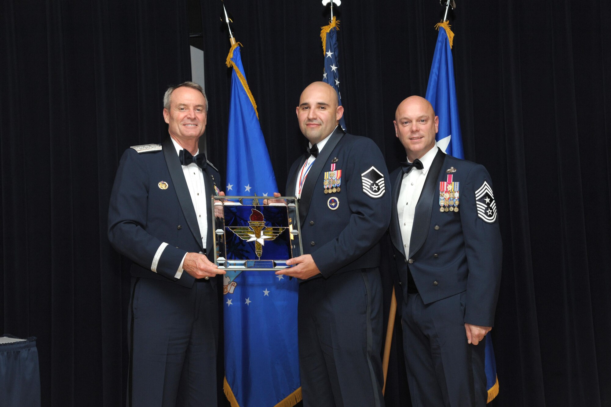 Master Sgt. Raul Hernandez Jr., 326th Training Squadron, Joint Base San Antonio-Lackland, Texas, receives an award from Lt. Gen. Darryl Roberson, commander, Air Education and Training Command and AETC Command Chief Master Sgt. David Staton during a ceremony here, June 16. Hernandez was selected as the AETC Military Training Instructor of the Year. (U.S. Air Force photo by Joel Martinez)