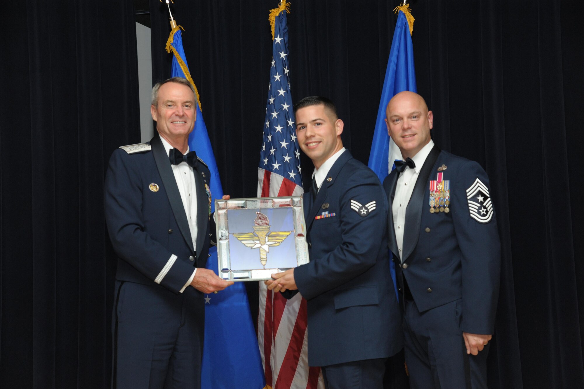 Senior Airman Jan Diaz Garcia, 56th Maintenance Group, Luke Air Force Base, Arizona, receives an award from Lt. Gen. Darryl Roberson, commander, Air Education and Training Command and AETC Command Chief Master Sgt. David Staton during a ceremony here, June 16. Diaz Garcia was selected as the AETC Honor Guard Member of the Year. (U.S. Air Force photo by Joel Martinez)