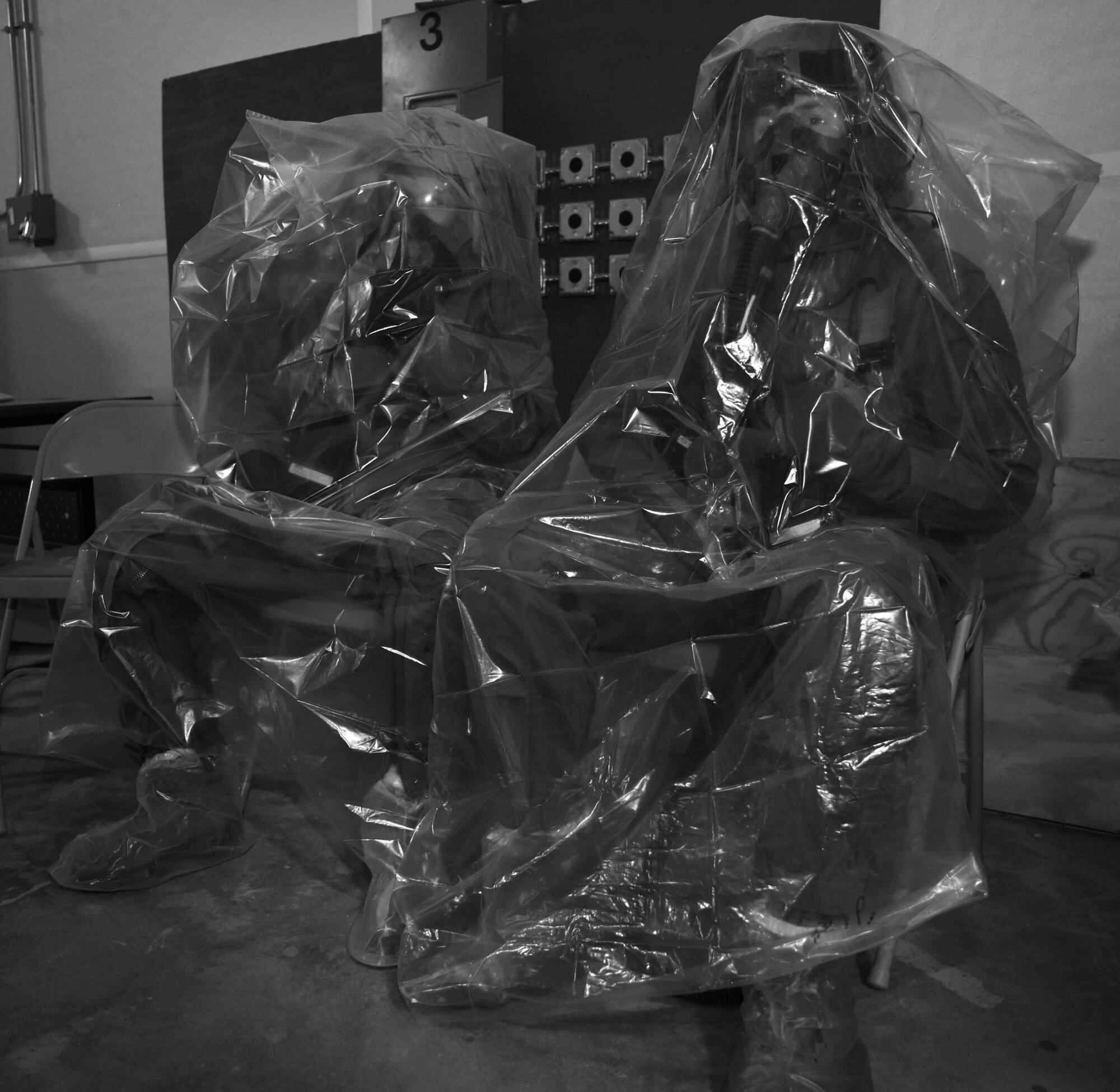 Aircrew members sit in plastic bags before processing a simulated decontamination line at Hurlburt Field, Fla., June 9, 2016. Air Force Special Operations Command’s operations directorate ran a realistic, scenario-based, training program for 16 aircrew flight equipment (AFE) Airmen from eight southern United States bases. (U.S. Air Force photo / Staff Sgt. Melanie Holochwost)