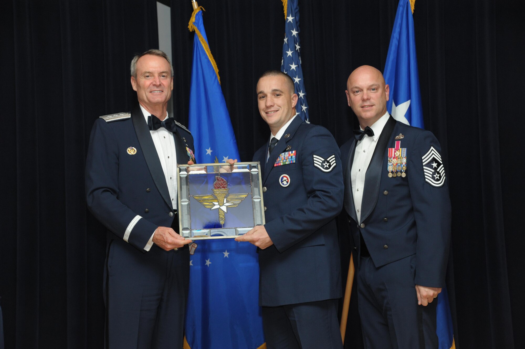Staff Sgt. Richard Bates, 47th Flying Training Wing, Laughlin Air Force Base, Texas, receives an award from Lt. Gen. Darryl Roberson, commander, Air Education and Training Command and AETC Command Chief Master Sgt. David Staton during a ceremony here, June 16. Bates was selected as the AETC Honor Guard Program Manager of the Year. (U.S. Air Force photo by Joel Martinez)