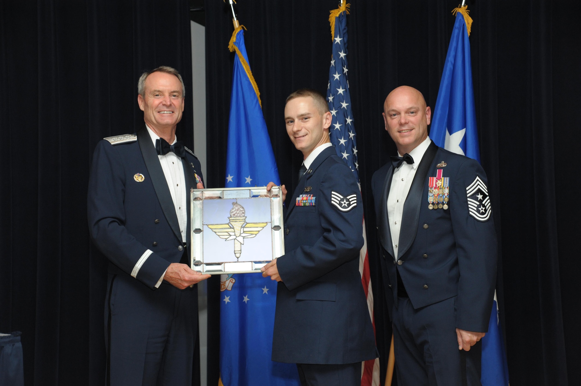 Staff Sgt. Cody Sparks, 47th Communications Squadron, Laughlin Air Force Base, Texas, receives an award from Lt. Gen. Darryl Roberson, commander, Air Education and Training Command and AETC Command Chief Master Sgt. David Staton during a ceremony here, June 16. Sparks was selected as the AETC Airman of the Year. (U.S. Air Force photo by Joel Martinez)