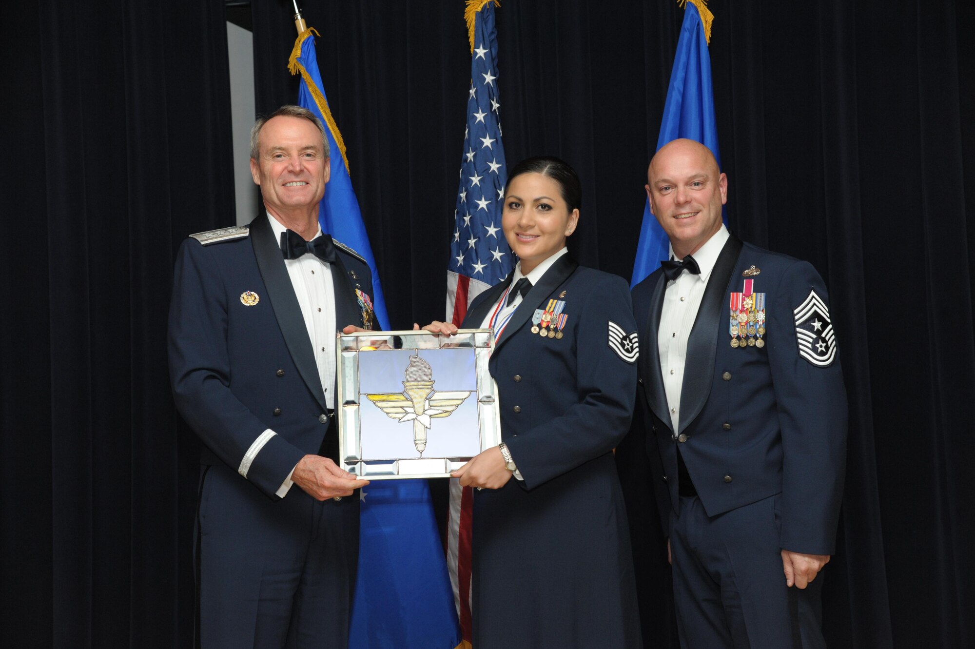 Tech. Sgt. Cassandra Cruz, 81st Force Support Squadron, Keesler Air Force Base, Mississippi, receives an award from Lt. Gen. Darryl Roberson, commander, Air Education and Training Command and AETC Command Chief Master Sgt. David Staton during a ceremony here, June 16. Cruz was selected as the AETC NCO of the Year. (U.S. Air Force photo by Joel Martinez)