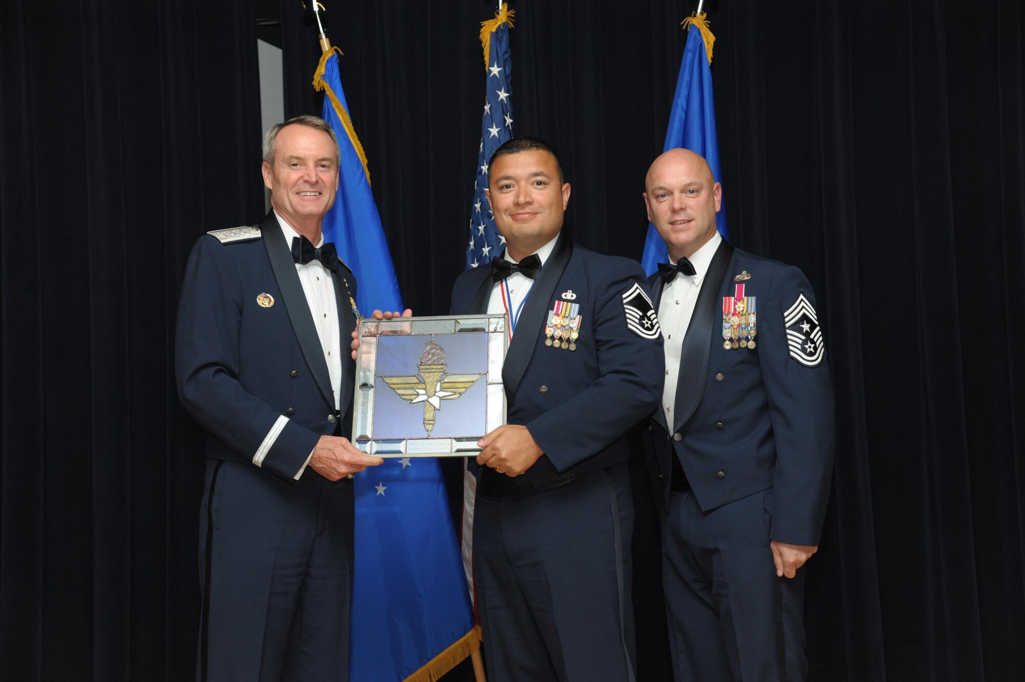 Senior Master Sgt. Joseph Arce, 14th Operations Support Squadron, Columbus Air Force Base, Mississippi, receives an award from Lt. Gen. Darryl Roberson, commander, Air Education and Training Command and AETC Command Chief Master Sgt. David Staton during a ceremony here, June 16. Arce was selected as the AETC Senior NCO of the Year. (U.S. Air Force photo by Joel Martinez)