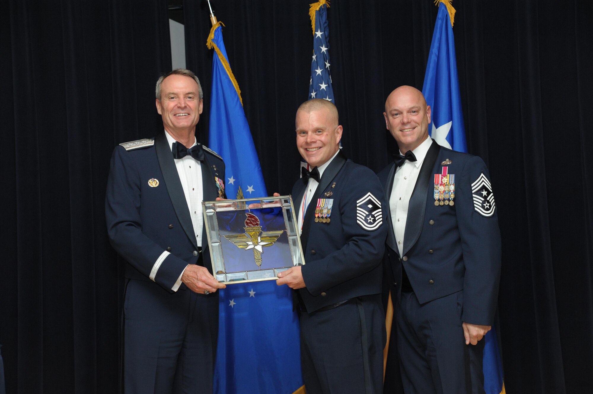 Senior Master Sgt. Jason Dahlquist, 326th Training Squadron, Joint Base San Antonio-Lackland, Texas, receives an award from Lt. Gen. Darryl Roberson, commander, Air Education and Training Command and AETC Command Chief Master Sgt. David Staton during a ceremony here, June 16. Dahlquist was selected as the AETC First Sergeant of the Year. (U.S. Air Force photo by Joel Martinez)