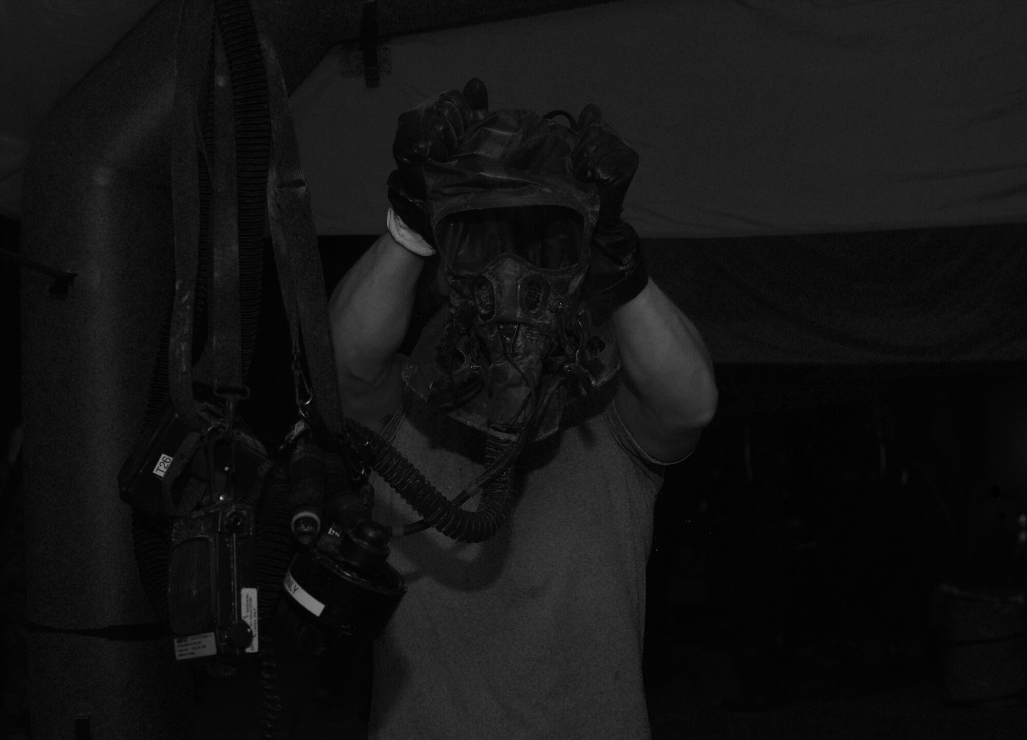 An aircrew member removes his helmet in a simulated decontamination line at Hurlburt Field, Fla., June 9, 2016.  (U.S. Air Force photo/Staff Sgt. Melanie Holochwost)