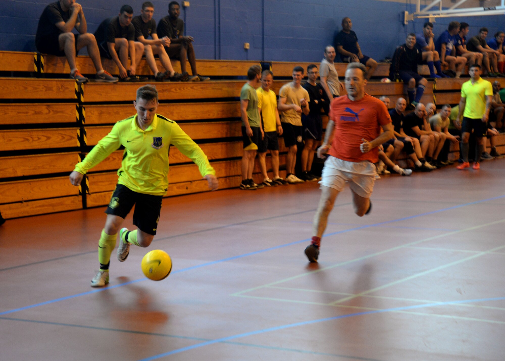 U.S. Air Force Airmen assigned to the 100th Civil Engineer Squadron and 100th Air Refueling Wing staff agencies compete at indoor soccer during a Marauder Melee event June 16, 2016, on RAF Mildenhall, England. The event was designed to foster morale and friendly competition through sports, games and a concert for Airmen and their families. (U.S. Air Force photo by Staff Sgt. Kate Thornton/Released)