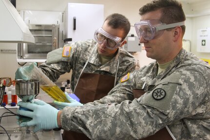 U.S. Army Reserve Sgt. Robert White, a native of Aliquippa, Pa., left, and Spc. Shawn See, a native of Hubbard, Ohio, both petroleum laboratory specialists assigned to the 475th Quartermaster Group, based out of Farrell, Pa., pour fuel into the Articulate Contaminate measuring the amount of contaminants at Fort A.P. Hill, Va.  The group is testing fuel for contamination that will be used by aircraft and ground vehicles during the 2016 Quartermaster Liquid Logistics Exercise.  (U.S. Army photo by Spc. Jack Hillard, 372nd Mobile Public Affairs Detachment)