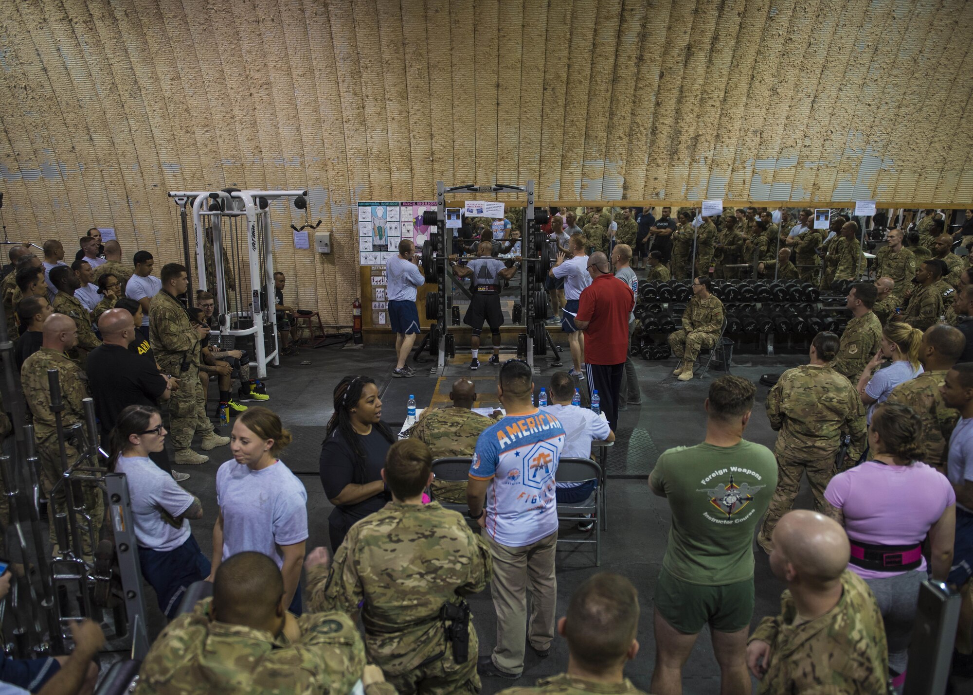 Military and coalition personnel gather around the deadlifting portion of Bagram’s Strongest Woman and Man competition, June 18, 2016, Bagram Airfield, Afghanistan. Competitors competed in multiple events to include squat, deadlift, and bench press. (U.S. Air Force photo by Senior Airman Justyn M. Freeman)
