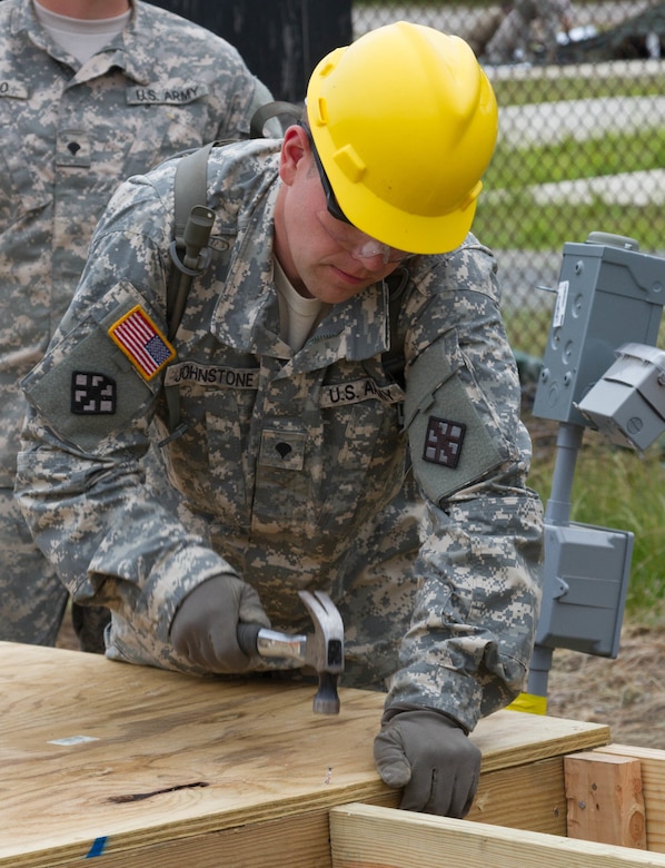 JOINT BASE MCGUIRE-DIX-LAKEHURST, N.J. - Dallas, Pa. native Spc. Vince Johnstone of 412th Engineer Company, based in Scranton, Pa., hammers together a frame for a detainee complex during training exercise Castle Installation Related Construction 2016. (U.S. Army photo by Spc. Gary R. Yim, 372nd Mobile Public Affairs Detachment)