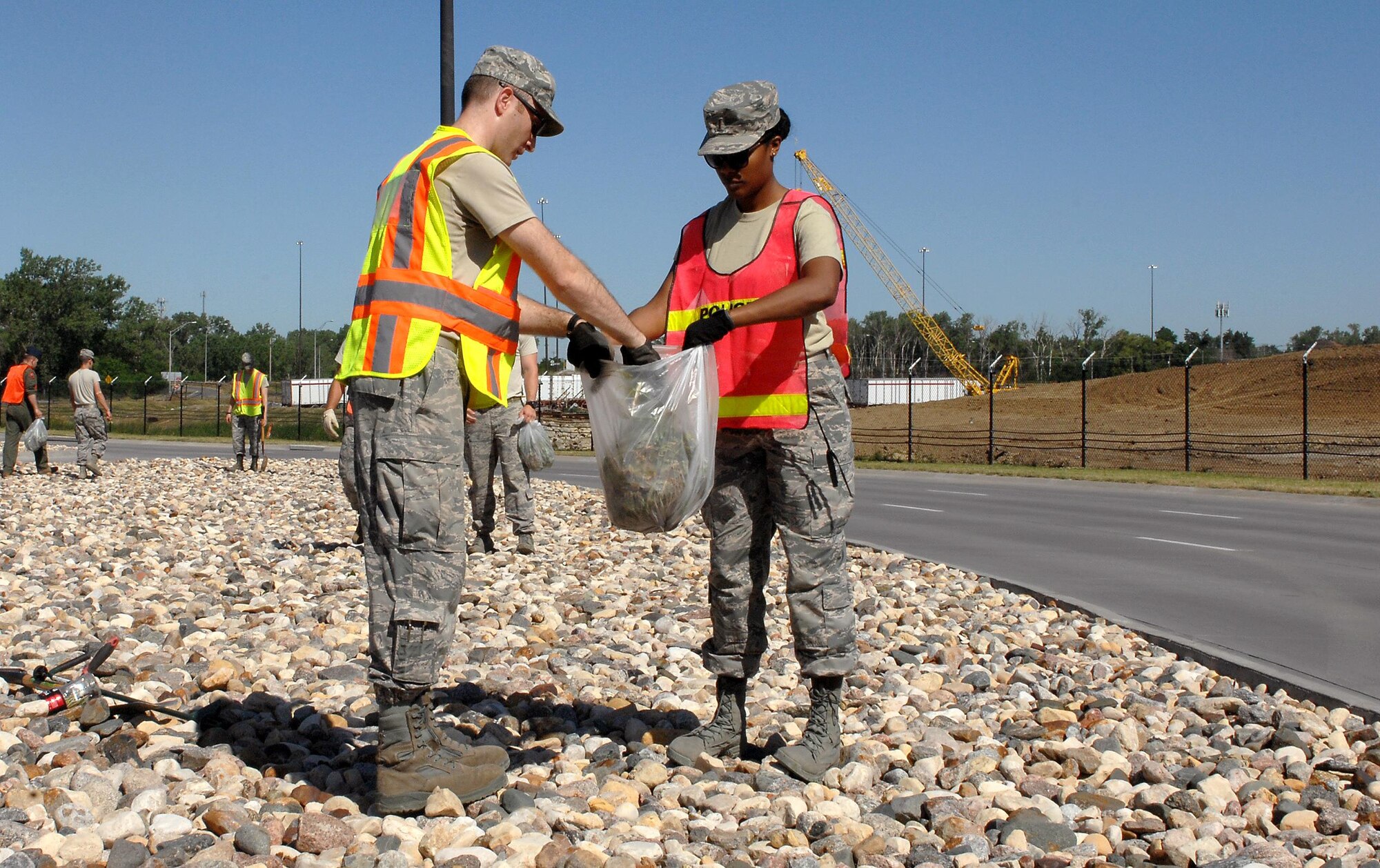 U.S. Air Force 1st Lieutenant Michael Day, 55th Operational Support Squadron, left, and U.S. Air Force 2nd Lt. Valyn Gipson, 55th Medical Support Squadron, pull weeds from the rock beds near Offutt’s STRATCOM gate June 15 while volunteering as part of the Installation Pride Initiative. (U.S. Air Force photo by Delanie Stafford/Released)