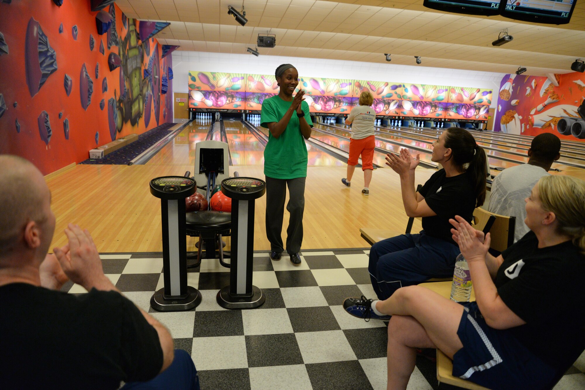 U.S. Air Force Airmen from the 100th Air Refueling Wing Wing Staff Agency celebrate after U.S. Air Force Tech. Sgt. Alicia Green, 100th Comptroller Squadron section chief bowled a strike, June 16, 2016, on RAF Mildenhall, England. The Marauder Melee sports competitions included volleyball, soccer and tennis. (U.S. Air Force photo by Senior Airman Christine Halan/Released)