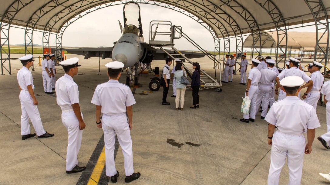 Japan Air Self-Defense Force aviation officer cadets from the Japan Maritime Self-Defense Force Ozuki Aviation Training Squadron observe an F/A-18C static display during a Japanese Officer Exchange Program tour at Marine Corps Air Station Iwakuni, Japan, June 17, 2016. Hosted by Marine Aircraft Group 12, the exchange program aims to better the understanding and working relationships between U.S. and Japanese pilots.
