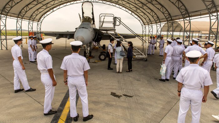 Japan Air Self-Defense Force aviation officer cadets from the Japan Maritime Self-Defense Force Ozuki Aviation Training Squadron observe an F/A-18C static display during a Japanese Officer Exchange Program tour at Marine Corps Air Station Iwakuni, Japan, June 17, 2016. Hosted by Marine Aircraft Group 12, the exchange program aims to better the understanding and working relationships between U.S. and Japanese pilots.