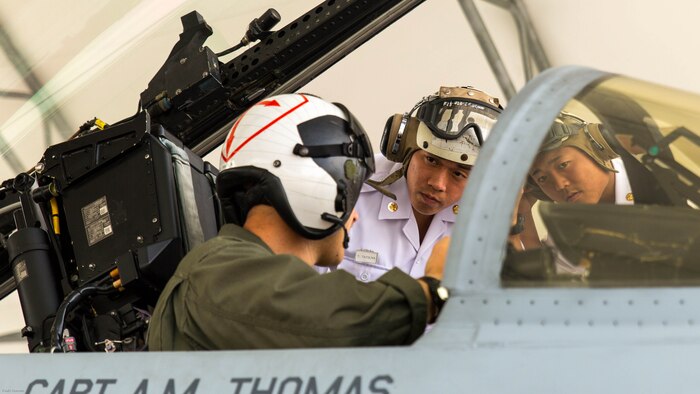 U.S. Marine Corps Capt. Daniel Lane, a pilot with Marine Fighter Attack Squadron 122, shows two Japan Maritime Self-Defense Force aviation officer cadets inside the cockpit of an F/A-18C during a Japanese Officer Exchange Program tour at Marine Corps Air Station Iwakuni, Japan, June 17, 2016. Hosted by Marine Aircraft Group 12, the exchange program aims to better the understanding and working relationships between U.S. and Japanese pilots. During the visit, 30 students from the JMSDF Ozuki Aviation Training Squadron from JMSDF Ozuki Air Base, Shimonoseki, toured the air station to see up close F/A-18C Hornets belonging to Marine Fighter Attack Squadron 122, took turns flying an F/A-18 flight simulator and learned MAG-12’s mission, organization, equipment, operations and flight training. 