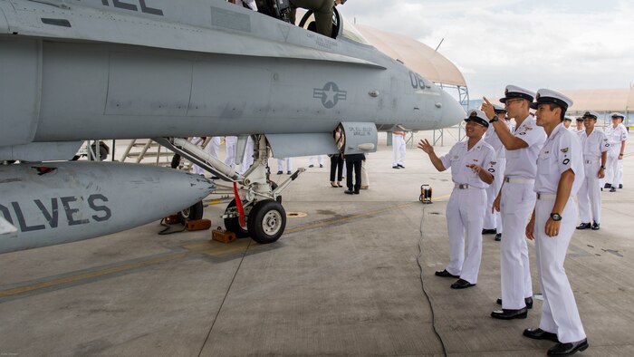 Japan Air Self-Defense Force aviation officer cadets from the Japan Maritime Self-Defense Force Ozuki Aviation Training Squadron observe and converse about an F/A-18C static display during a Japanese Officer Exchange Program tour at Marine Corps Air Station Iwakuni, Japan, June 17, 2016. Hosted by Marine Aircraft Group 12, the exchange program aims to better the understanding and working relationships between U.S. and Japanese pilots. The visit provides the cadets with greater knowledge and understanding of the present condition of the Marines in Japan. 