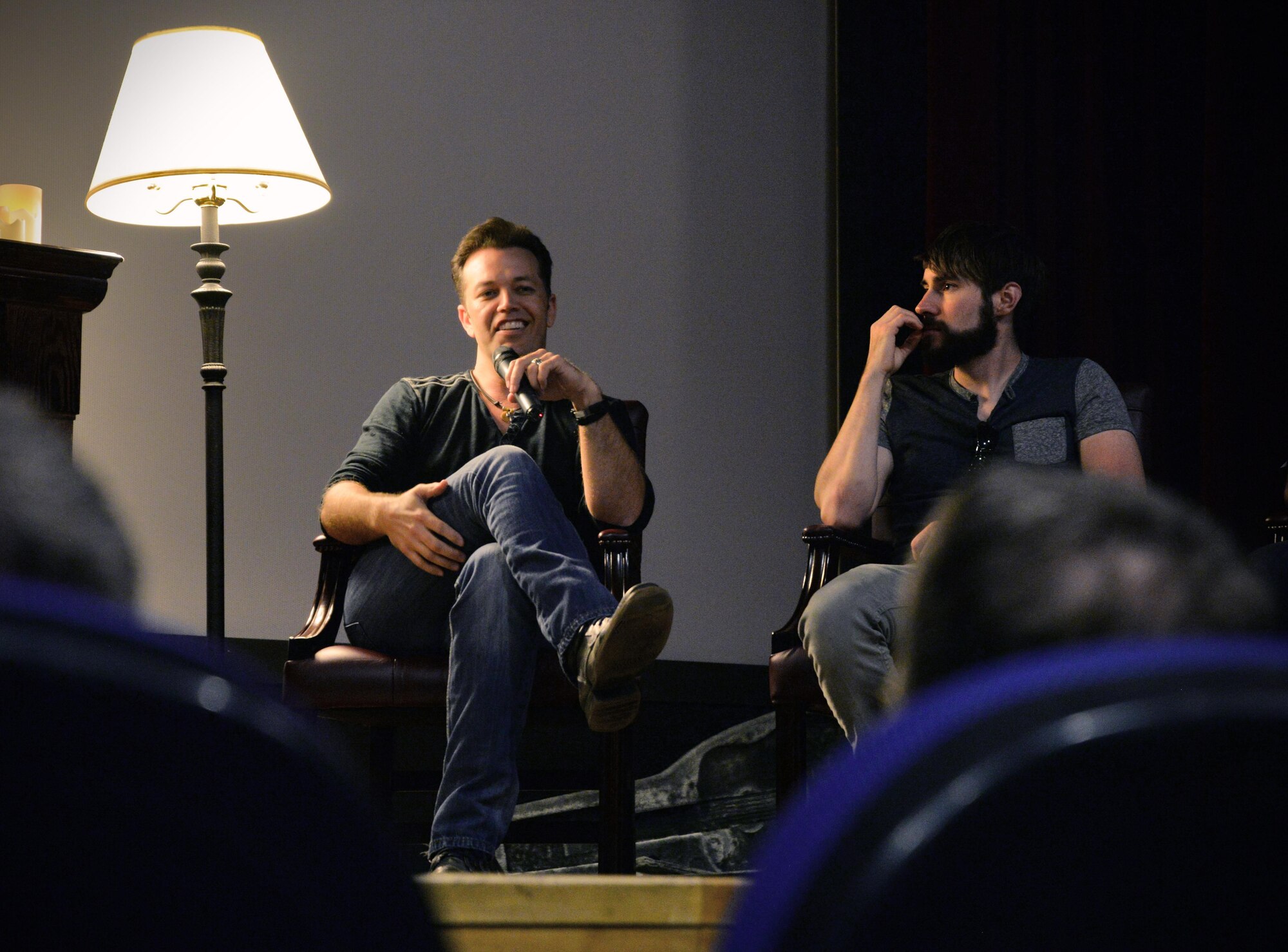 Lucas Hoge, left, country singer and song writer, answers a question from an audience member June 15, 2016, at the base theater on RAF Mildenhall, England. Hoge and his band spoke with Team Mildenhall members about the power of music and how it has helped him and others stay resilient. (U.S. Air Force photo by Senior Airman Christine Halan/Released)