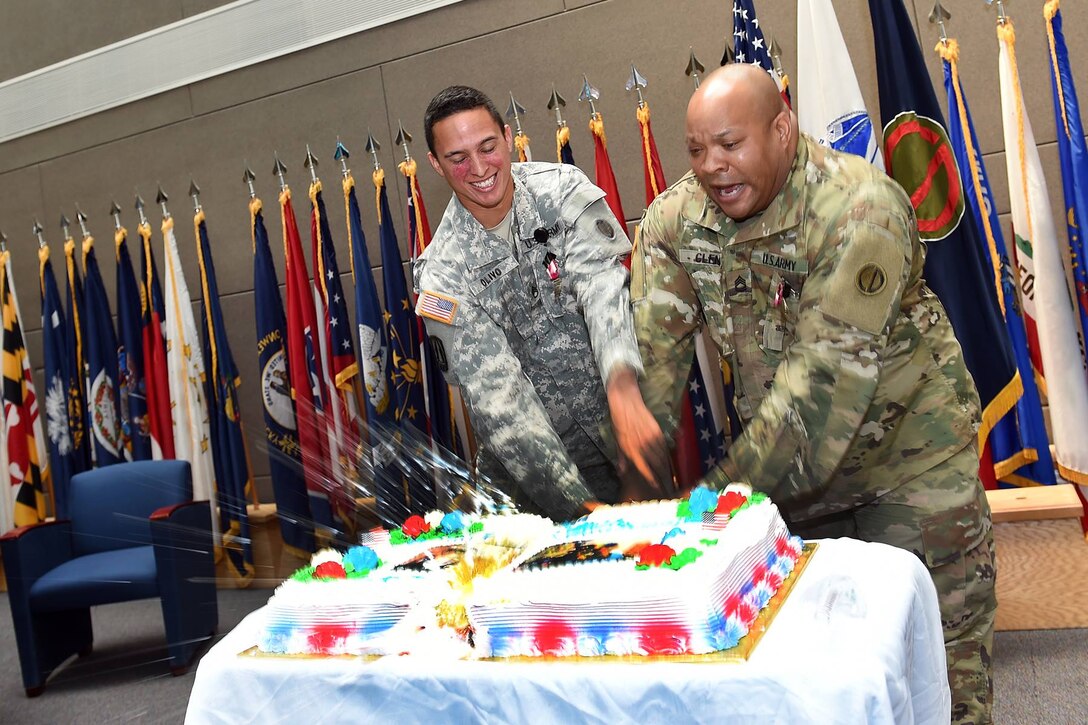 U.S. Army Reserve Staff Sgt. Angel Olivo, Information Technology Sergeant, 85th Support Command, and Sgt. 1st Class Kyle Glenn, Physical Security Sergeant, 85th Support Command, cut their farewell cake together on June 17, 2016. Both Glenn and Olivo have been integral soldiers within the command and will truly be missed. 
(Photo by Sgt. 1st Class Anthony L. Taylor)