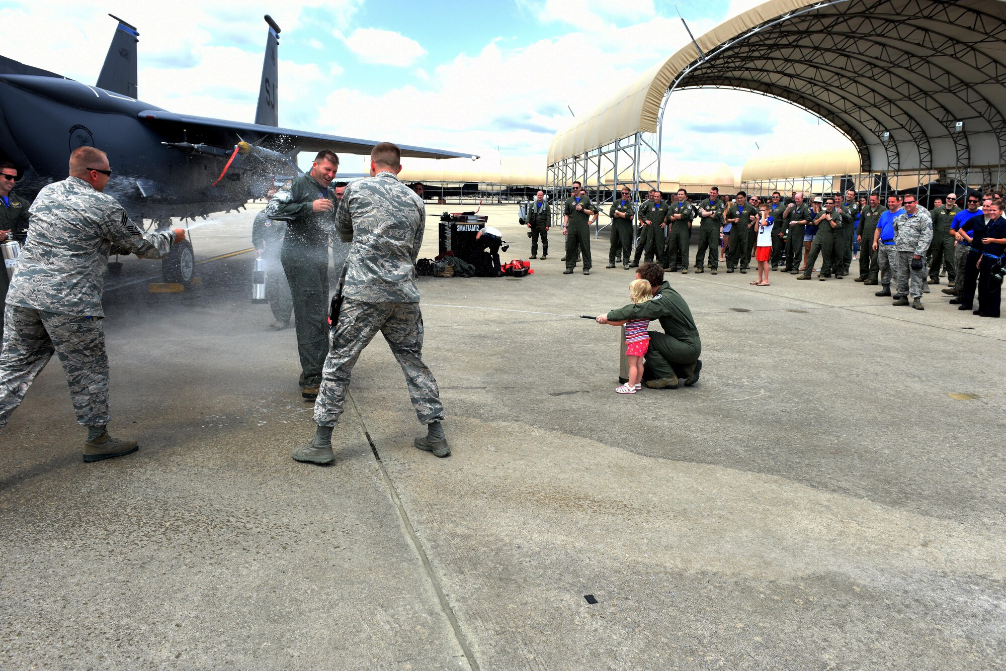 Lt. Col. Eric Schmidt, 334th Fighter Squadron director of operations is sprayed down by friends and family members following his final F-15E Strike Eagle flight June 17, 2016, at Seymour Johnson Air Force Base, North Carolina. Schmidt eclipsed 3,000 hours in the Strike Eagle and was greeted by many to celebrate the occasion. (U.S. Air Force photo/Tech. Sgt. Chuck Broadway)