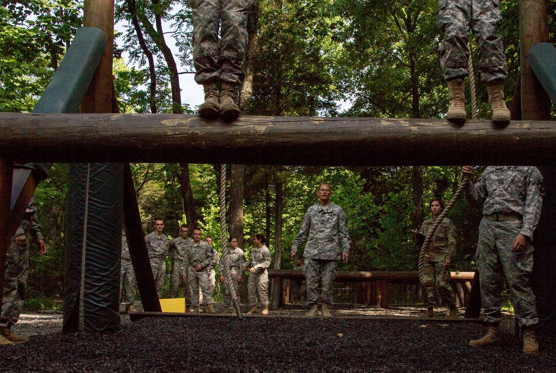 Army Reserve instructors attached to Task Force Wolf from Alpha Company, 2nd and 399th Training Battalion (ROTC) watch cadets attempt the swing, stop and jump obstacle on the confidence course during Cadet Summer Training event, Ft. Knox, Ky., July 19. (U.S. Army photo by Sgt. Karen Sampson/Released)