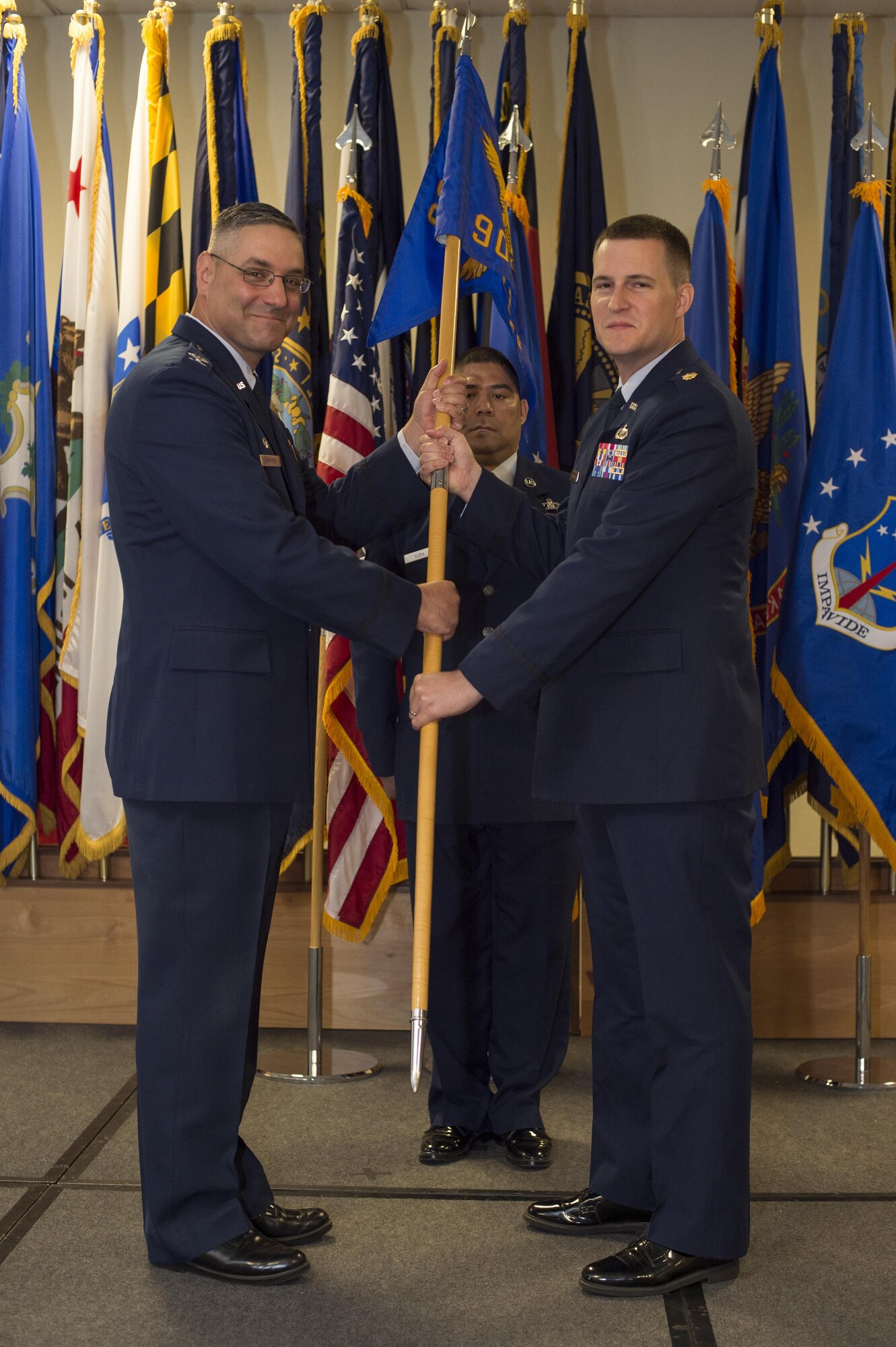 Maj. Andrew C. Wilkins, 90th Comptroller Squadron commander, takes the 90th CPTS guidon from Col. Stephen M. Kravitsky, 90th Missile Wing commander, during a change-of-command ceremony June 20, 2016, inside Trail’s End Community Center at F.E. Warren Air Force Base, Wyo. The passing of the guidon stems from military tradition, with the guidon symbolizing a flag that soldiers would rally behind during battles. (U.S. Air Force photo By Staff Sgt. Christopher Ruano)