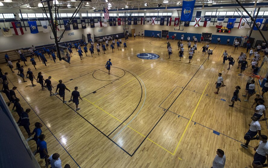 U.S. Air Force Staff Sgt. Alexandro Caraballo, 23d Logistics Readiness Squadron material manager, leads the 23d Mission Support Group in warm-up stretches, June 17, 2016, at Moody Air Force Base, Ga. The 23d MSG hosted a sports day and used friendly competition between its squadrons to boost morale. (U.S. Air Force photo by Airman 1st Class Janiqua P. Robinson/Released)