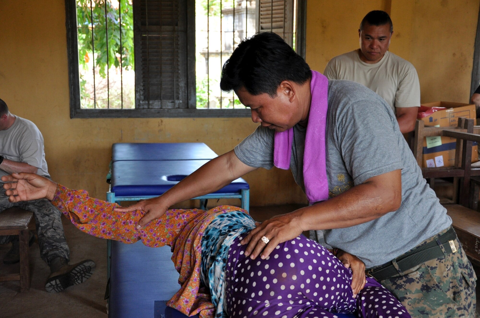 Royal Cambodian Air Force Capt. Tob Vuthy treats a patient for lower back pain June 14, 2016, during Pacific Angel 16-2 in Kampot Province, Cambodia. Multinational doctors, dentists and pharmacists treated patients in the province as part of the humanitarian assistance mission designed to enhance participating nations’ humanitarian assistance and disaster relief capabilities while providing needed services to people throughout the Indo-Asia-Pacific. Pacific Angel 16-2 included general health, dental, optometry, pediatrics, physical therapy and engineering programs as well a various subject-matter expert exchanges. (U.S. Air Force photo by Capt. Susan Harrington/Released)