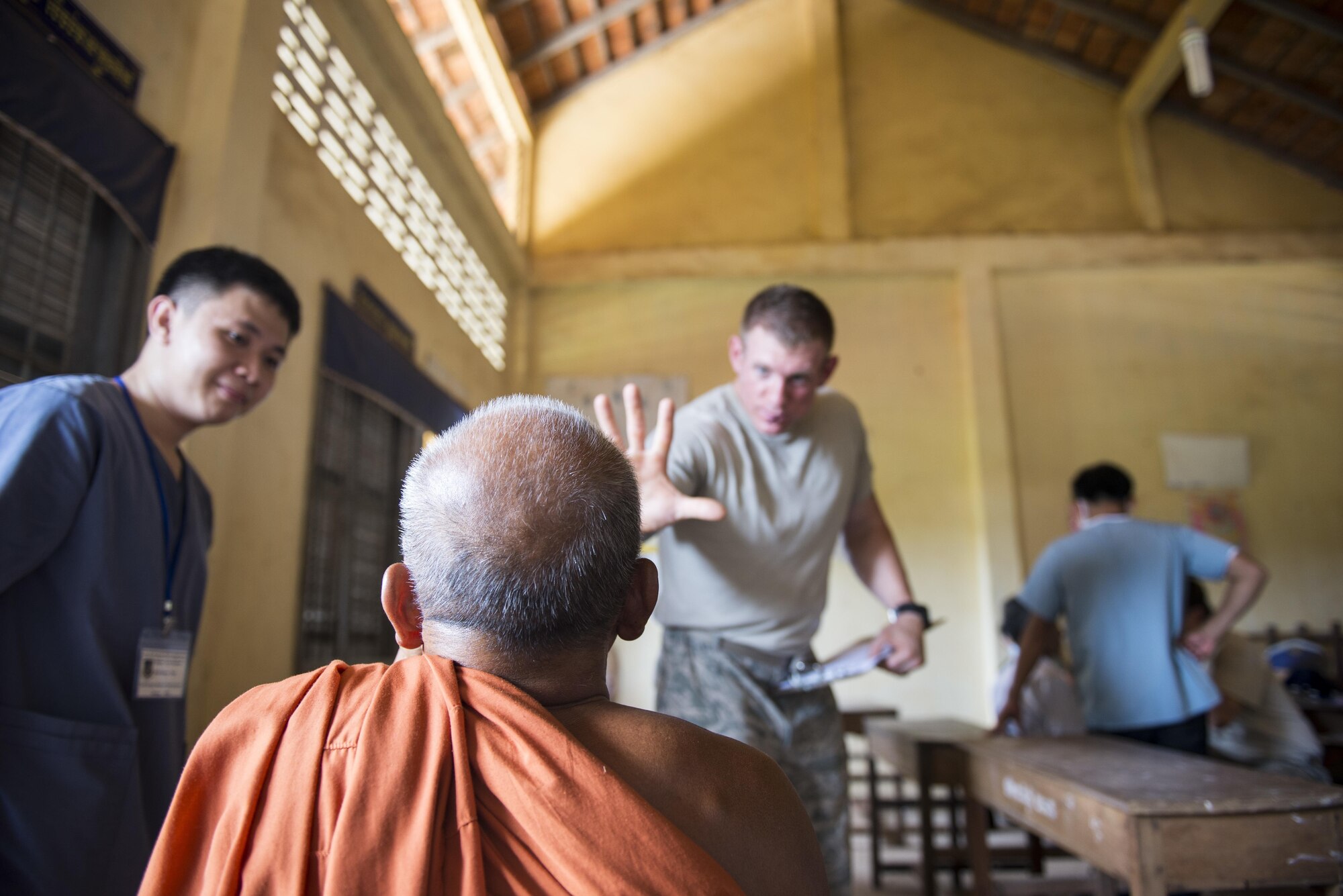 U.S. Air Force Staff Sgt. Cullen Babcock, Joint Base Pearl Harbor-Hickam’s 15th Aerospace Medicine Squadron, conducts an eye exam on a Cambodian Buddhist monk during Pacific Angel 16-2 June 14, 2016,  in Kampot Province, Cambodia. Babcock and other technicians conducted on patients ranging from ages 2 to 91. Pacific Angel gives the United States an opportunity to support the efforts of other governments in the region to provide medical, dental, optometry, physical therapy, engineering assistance, and subject matter expert exchanges to host nation citizens.  (U.S. Air Force photo by Senior Airman Omari Bernard/Released)