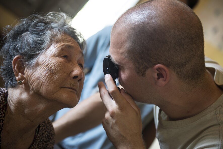 Maj. Brandon Harris, an optometrist with the 374th Aerospace Medicine Squadron from Yokota Air Base, Japan, examines the eyes of a patient during Pacific Angel 16-2 in the Kampot province, Cambodia, June 14, 2016. Skilled medics from both military and nongovernmental agencies around the globe provided quality hospital care to patients during Pacific Angel 16-2, which helped to cultivate common bonds and foster goodwill between the U.S., Cambodia and several nations by conducting multilateral humanitarian assistance and civil military operations. (U.S. Air Force photo/Senior Airman Omari Bernard)