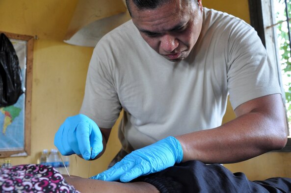 U.S Air Force Maj. Villanueva dry needles a patient in order to aid in relieving lower back-pain June 14, 2016, in Kampot Province, Cambodia. Throughout the course of the week doctors, dentists, and pharmacists from the U.S., Cambodia, Australia, Vietnam and Thai militaries and two non-governmental organizations, along with 65 volunteers from the provincial hospital and local villages, saw more than 3,400 patients at two different sites. Together they provided general health, dental, optometry, pediatrics, and physical therapy services. (U.S. Air Force photo by Capt. Susan Harrington/Released)