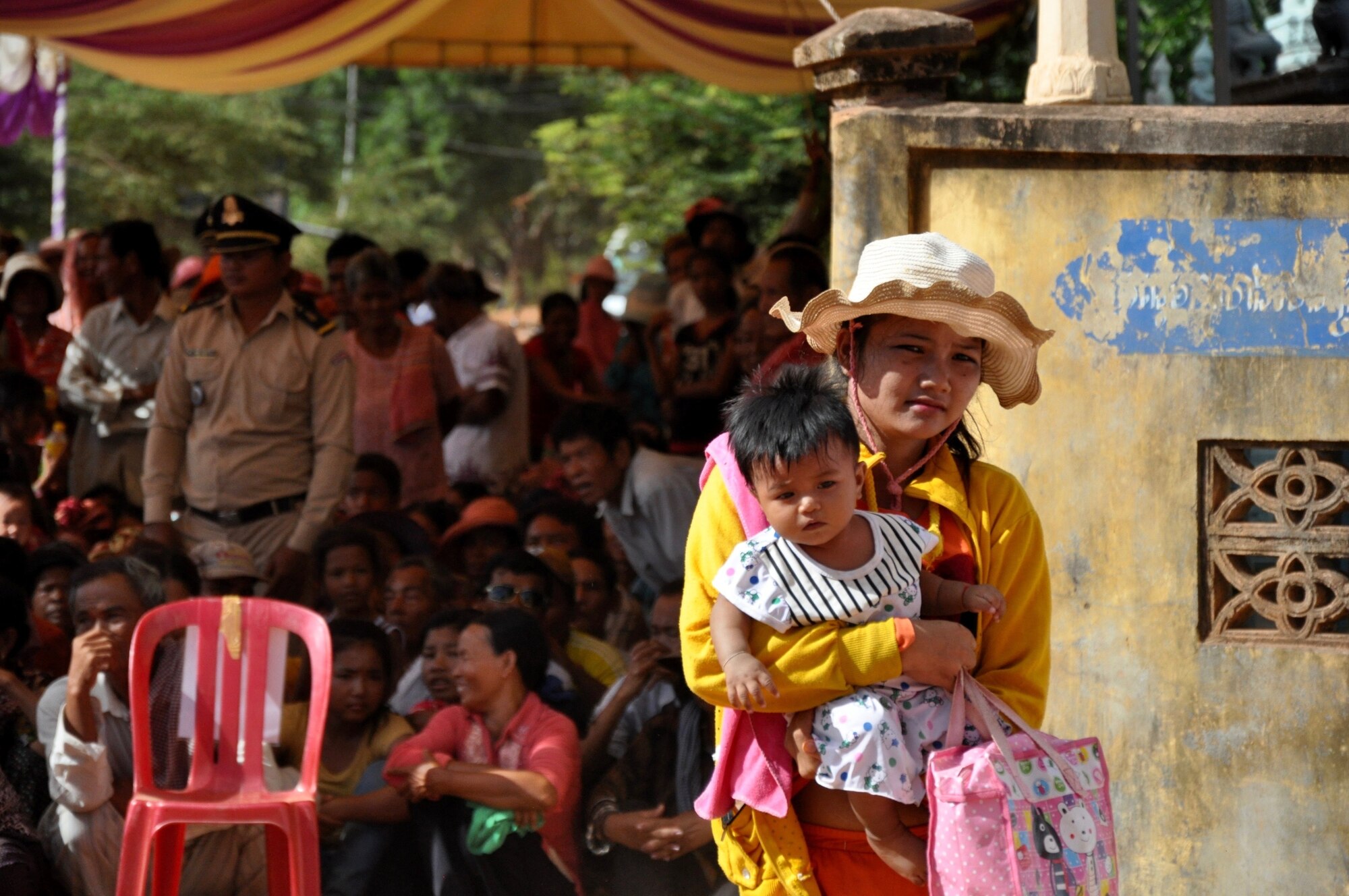 A young Cambodian women takes her child to be seen at the Ang Chum Trapaing Chhuk Junior High School where military and civilian medical providers from the U.S., Cambodia, Thailand, Australia and Vietnam set up a health services outreach clinic June 15, 2016. The clinic was set up as part of Pacific Angel 16-2, a humanitarian assistance mission designed to enhance participating nations’ humanitarian assistance and disaster relief capabilities while providing needed services to people throughout the Indo-Asia-Pacific. Pacific Angel 16-2 included general health, dental, optometry, pediatrics, physical therapy and engineering programs as well a various subject-matter expert exchanges. (U.S. Air Force photo by Capt. Susan Harrington/Released)