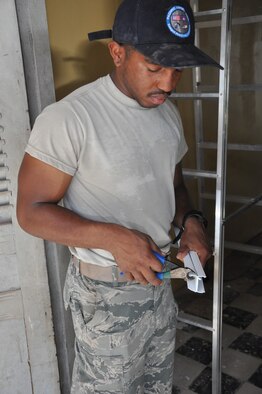 Airman First Class Demarcus Smith, an electrical systems apprentice with the 647th Civil Engineer Squadron, Joint Base Pearl Harbor-Hickam, Hawaii, uses clippers to shorten a panel, June 16, 2016, as part of Pacific Angel 16-2 in Kampot Province, Cambodia. Smith, along with a team of U.S., Cambodian and Australian engineers worked to repair four local schools and two provincial health clinics during the humanitarian mission designed to promote interoperability between partner nations. (U.S. Air Force photo by Capt. Susan Harrington/Released)