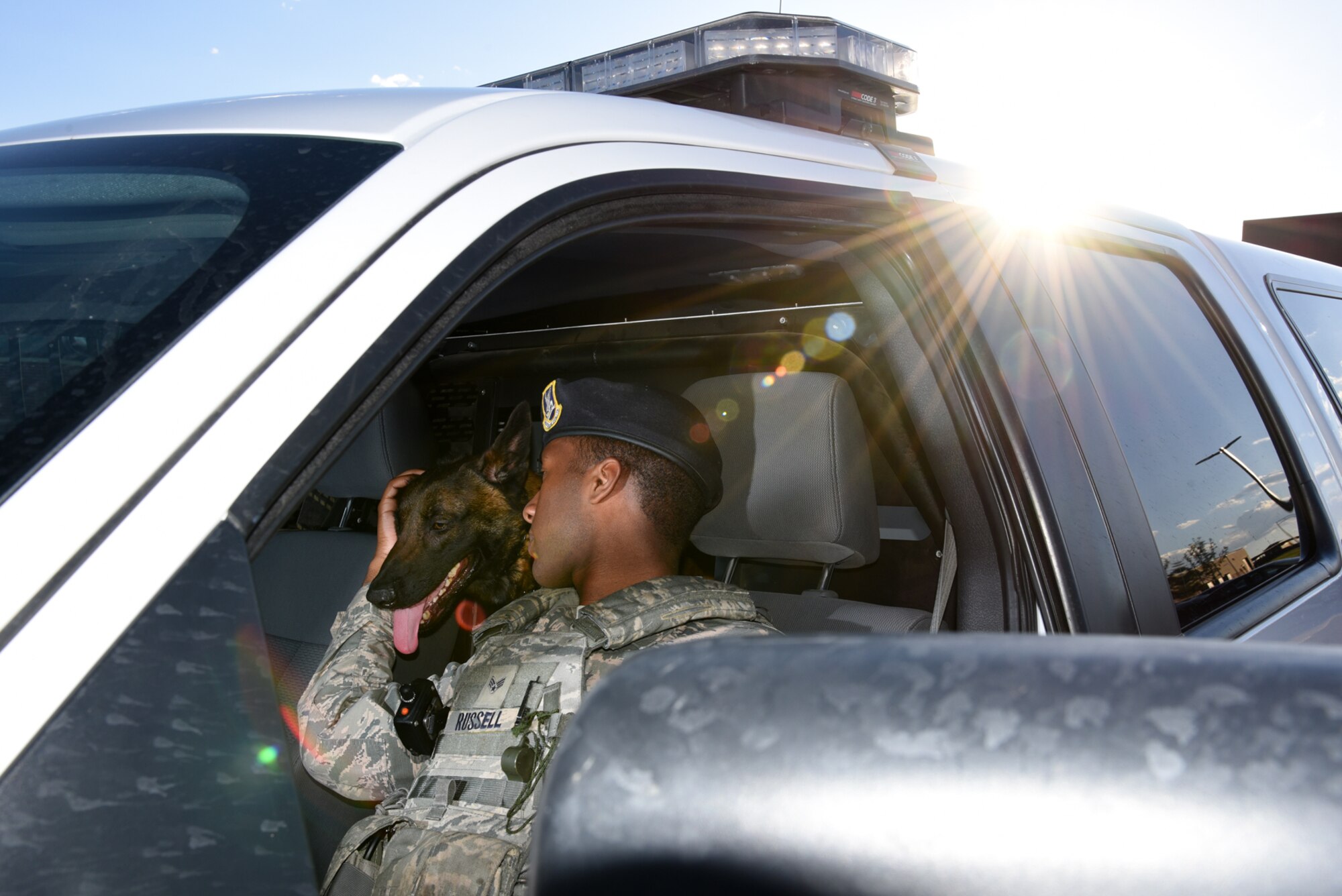 Senior Airman Tariq Russell, 21st Security Forces Squadron military working dog handler, praises his dog, Ppaul, before heading to his next job at Peterson Air Force Base, Colo., June 14, 2016. The relationship between Russell and Ppaul was commended by leadership as being one of the strongest they have witnessed. (U.S. Air Force photo by Airman 1st Class Dennis Hoffman)