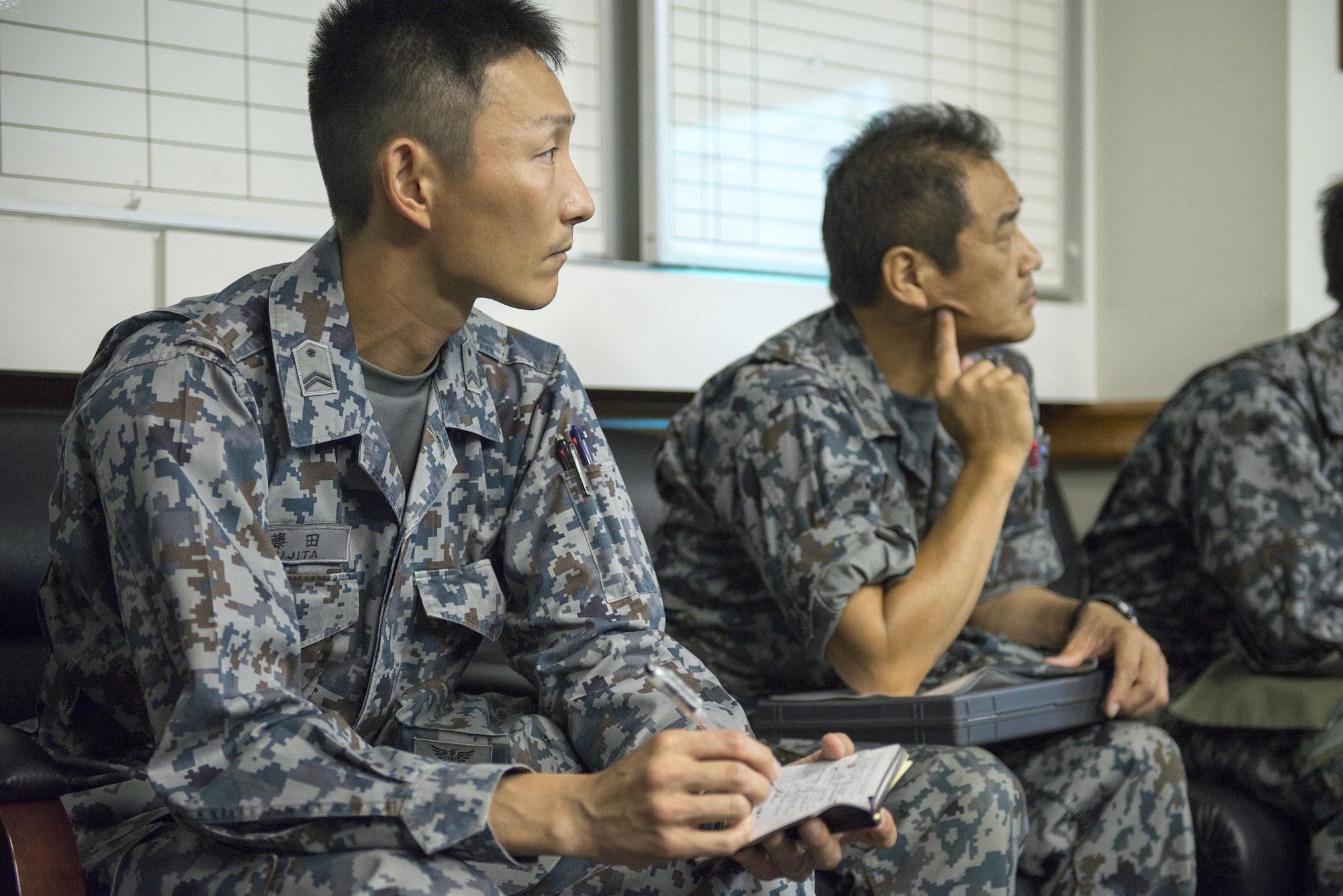A Japan Air Self-Defense Force member takes notes during a Prime Base Engineer Emergency Force briefing hosted by the 374th Civil Engineer Squadron at Yokota Air Base, Japan, June 16, 2016. The briefing covered airfield damage repair capabilities and procedures used by the 374 CES. (U.S. Air Force photo by Senior Airman David C. Danford/Released)