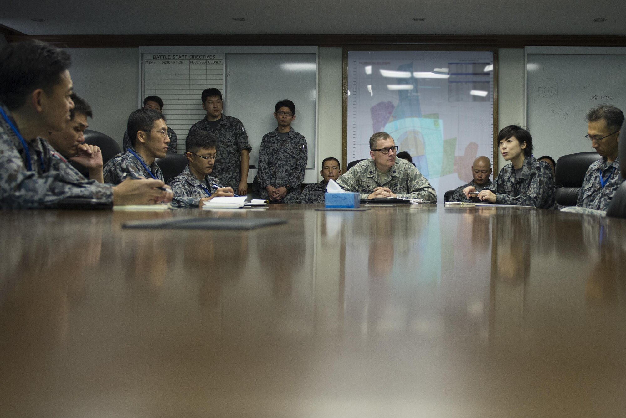 Lt. Col. David McCleese, 374th Civil Engineer Squadron commander, listens as his words are translated to Japanese for Japan Air Self-Defense Force personnel from Iruma Air Base at Yokota Air Base, Japan, June 16, 2016. The briefing covered airfield damage repair capabilities and procedures used by the 374 CES. (U.S. Air Force photo by Senior Airman David C. Danford/Released)