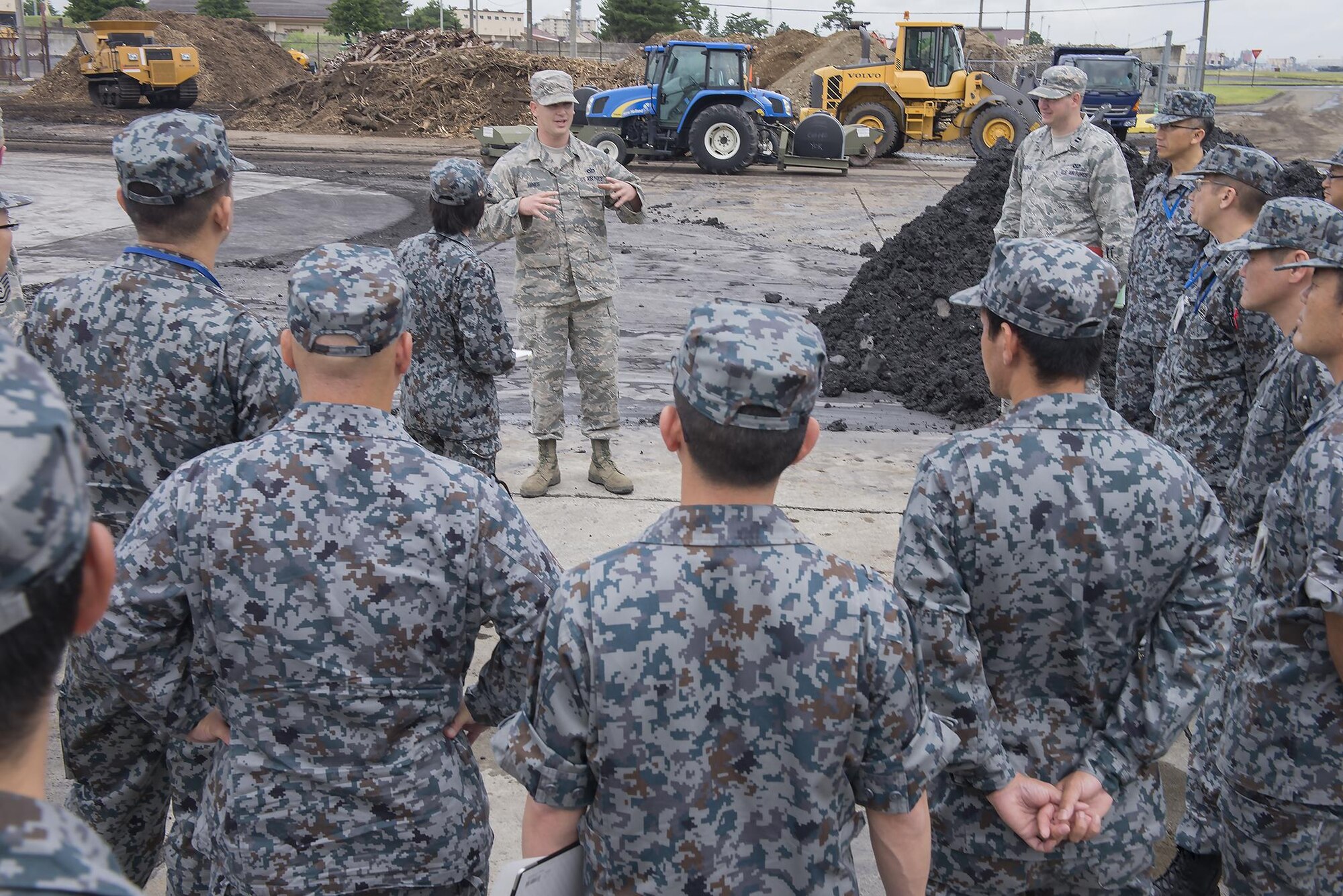 Tech. Sgt. Marcus Hines, 374th Civil Engineer Squadron NCO in charge of pavements and equipment, briefs Japan Air Self-Defense Force members on the airfield damage repair capabilities at Yokota Air Base, Japan, June 16, 2016. As part of the tour, the 374 CES demonstrated ADR and flightline emergency procedures. (U.S. Air Force photo by Senior Airman David C. Danford/Released)