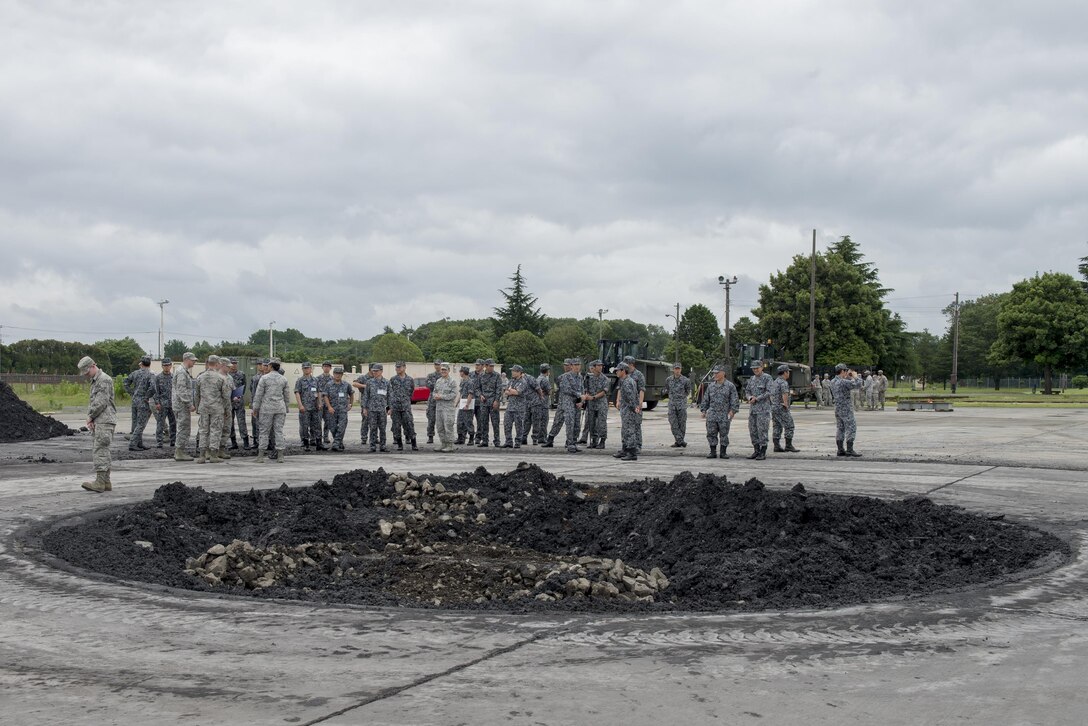 Japan Air Self-Defense Force members tour the 374th Civil Engineer Squadron's airfield damage repair training ground at Yokota Air Base, Japan, June 16, 2016. As part of the tour, the 374 CES demonstrated ADR and flightline emergency procedures. (U.S. Air Force photo by Senior Airman David C. Danford/Released)