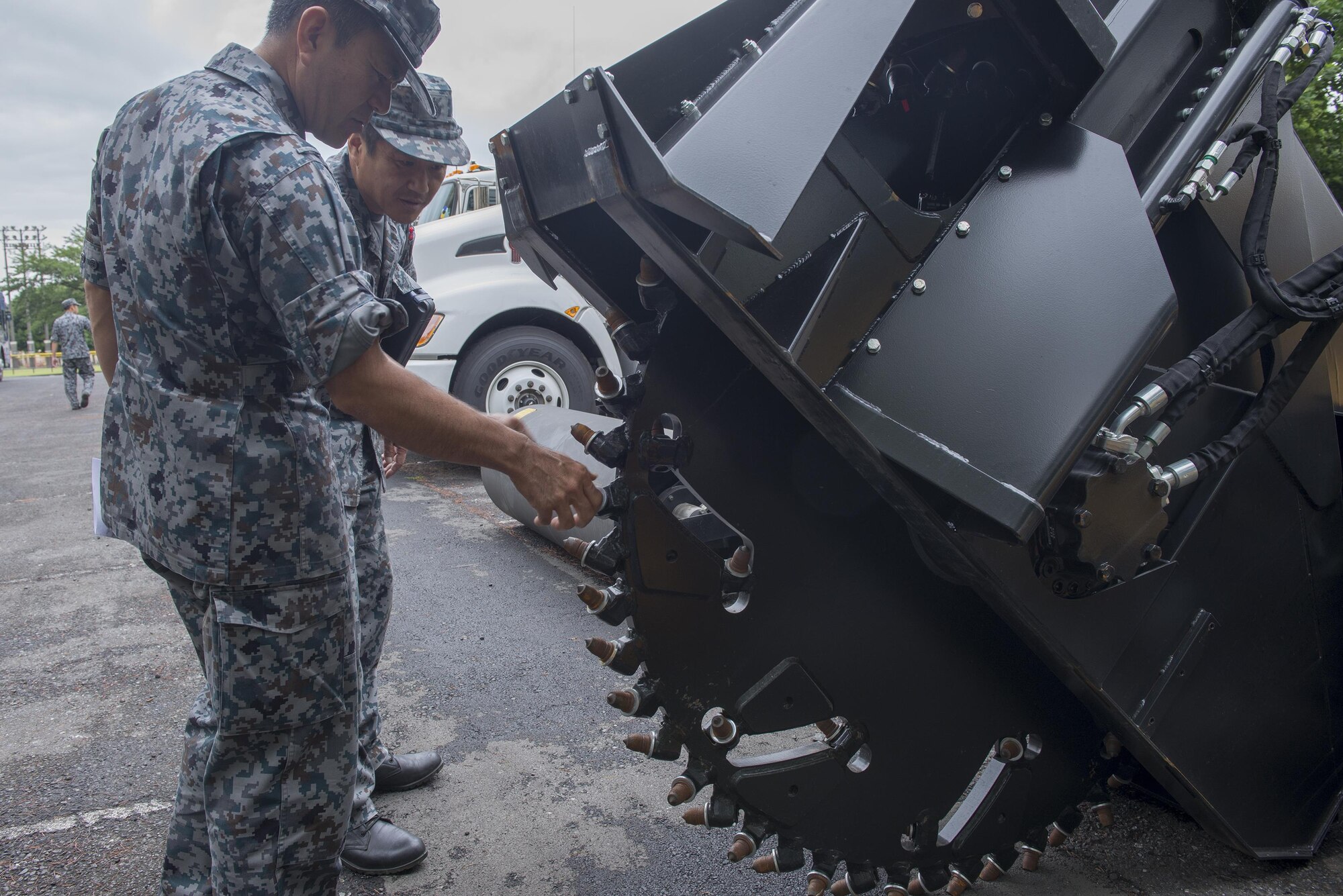 Japan Air Self-Defense Force members are shown skid-steer loaders with different attachments during a Prime Base Engineer Emergency Force tour at Yokota Air Base, Japan, June 16, 2016. The loader is a small, rigid-frame machine with lift arms used to attach a wide variety of labor-saving tools. (U.S. Air Force photo by Senior Airman David C. Danford/Released)