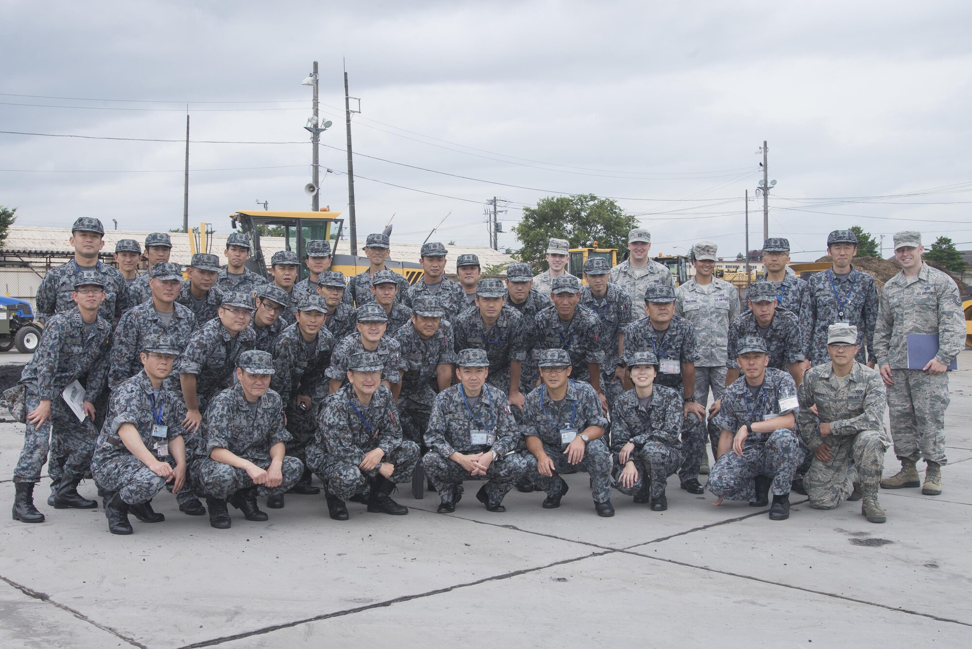 Japan Air Self-Defense Force members pose for a group photo with Yokota Airmen, after a tour at Yokota Air Base, Japan, June 16, 2016. As part of the tour, the 374th Civil Engineer Squadron demonstrated airfield damage repair and flightline emergency procedures. (U.S. Air Force photo by Senior Airman David C. Danford/Released)
