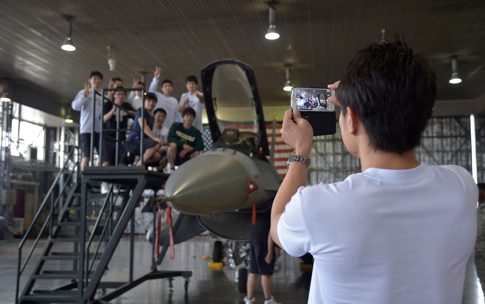 Members of the Japan Railway East Akita Peckers basketball team tour a static display of an F-16 Fighting Falcon at Misawa Air Base, Japan, June 17, 2016. The team was briefed on the 35th Fighter Wing mission and viewed F-16s before taking part in a basketball camp and game. (U.S. Air Force photo by Senior Airman Deana Heitzman)