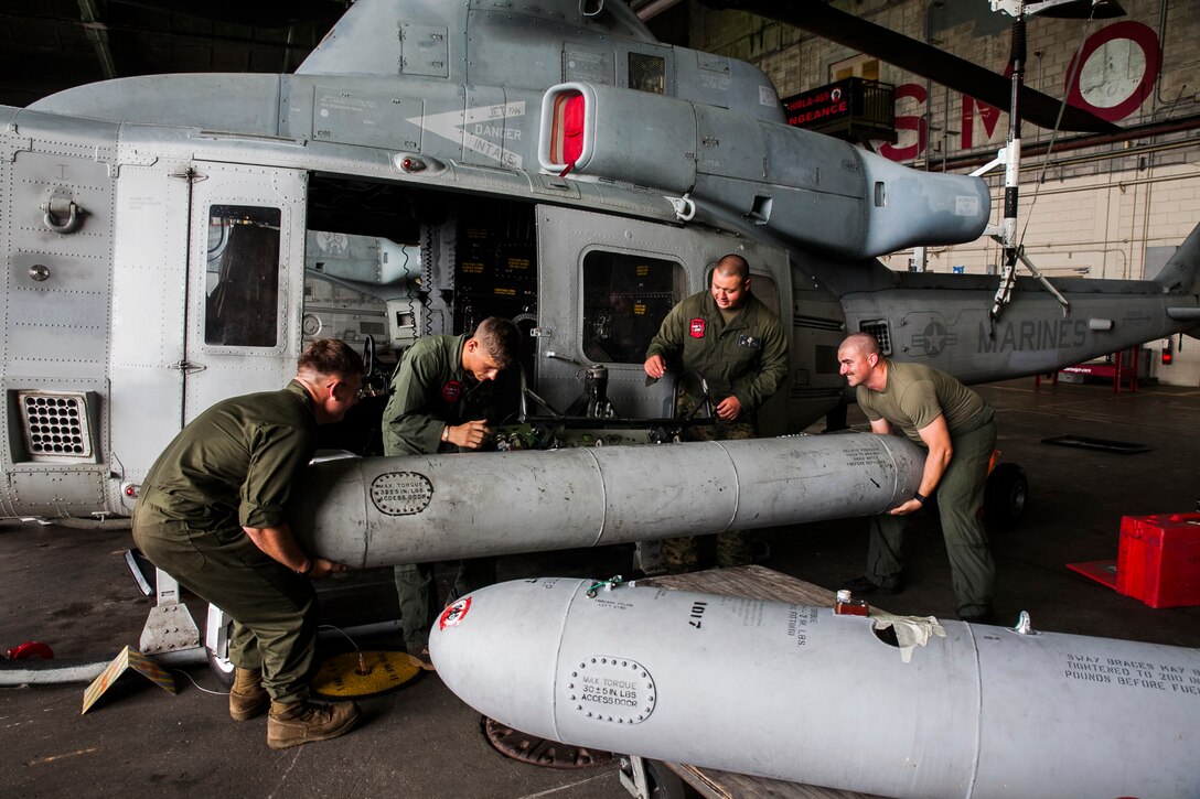 Auxiliary fuel tanks for the UH-1Y Venom are installed onto the aircraft at Marine Corps Air Station Futenma, Okinawa, Japan, June 14, 2016. This is the first time in the Fleet Marine Force that the tanks will be installed and used. “For humanitarian missions, we can provide assistance more quickly and farther out,” said Maj. Carl A. Bailey, the executive officer of Marine Light Attack Helicopter Squadron (HMLA) 469, Marine Aircraft Group 39, 3rd Marine Aircraft Wing, currently assigned to Marine Aircraft Group 36, 1st Marine Aircraft Wing through the Unit Deployment Program. “The distances here are extreme, and there is a lot of water and not a lot of gas stations, so being able to strap on these aux-tanks, pick up and go, is going to be a game changer for us.” The Marines are with HMLA 469. (U.S. Marine Corps photo by Cpl. Tyler S. Giguere)