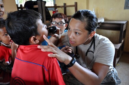 U.S. Air Force Staff Sgt. Sheena Raya Amaya examines a young Cambodian boy June 14, 2016, during Pacific Angel 16-2, a humanitarian assistance/civil-military operation in Kampot Province, Cambodia. Skilled medics from both military and non-governmental agencies around the globe came to provide hospital quality care to patients during the humanitarian assistance/civil military operation mission. Pacific Angel ensures that the region’s militaries are prepared to work together to address humanitarian crises in case of natural disasters. (U.S. Air Force photo by Capt. Susan Harrington/Released)