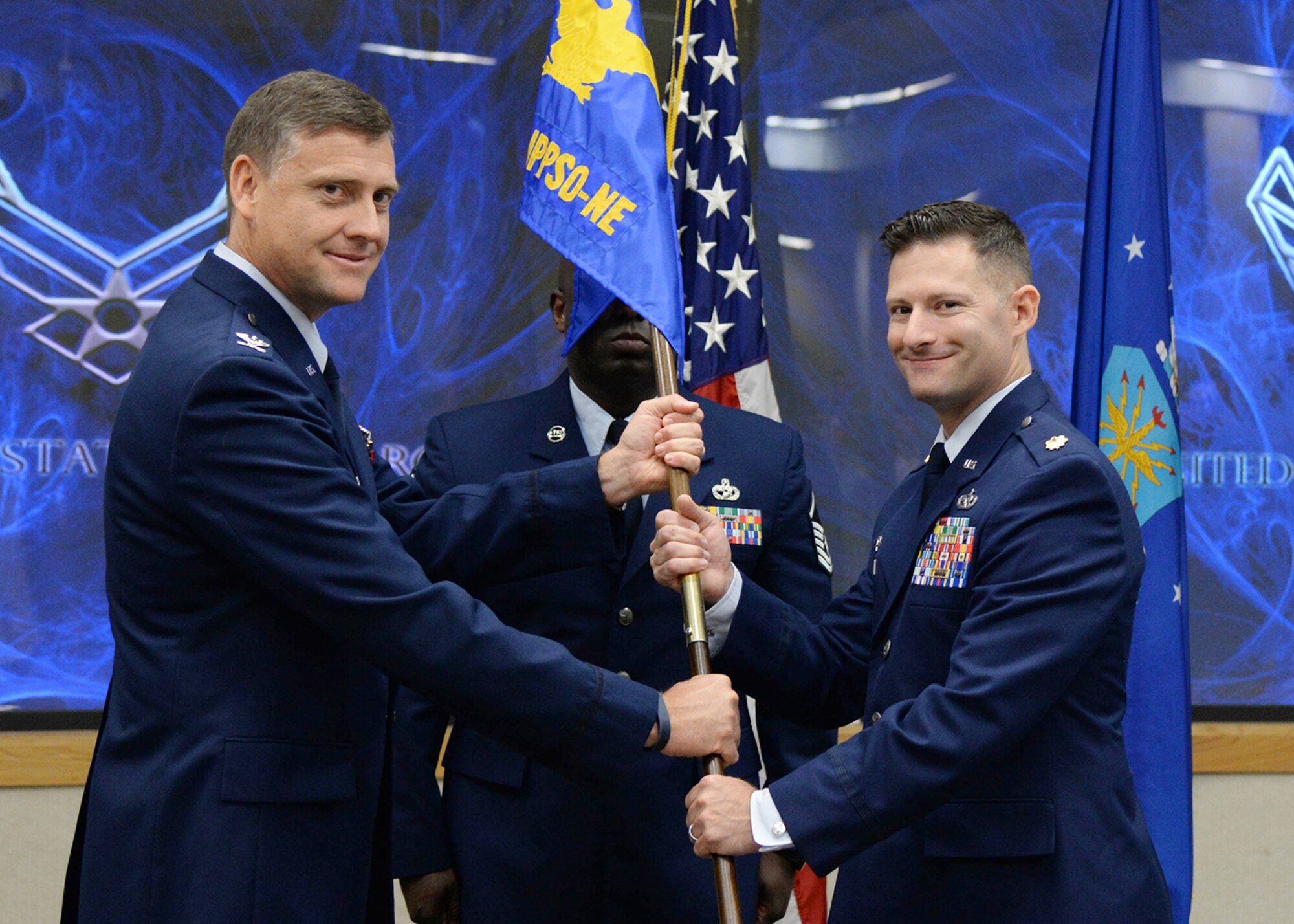 Col. Clifford G. Altizer, left, Personal Property Activity Headquarters commander, passes the guidon to Maj. Brent G. Tschikof during the Joint Personal Property Shipping Office Northeast Detachment 2 Change of Command ceremony at the base conference center June 17. JPPSO is responsible for the procurement of personal property movement and storage services for all Department of Defense components, including the Coast Guard. (U.S. Air Force photo by Linda LaBonte Britt)