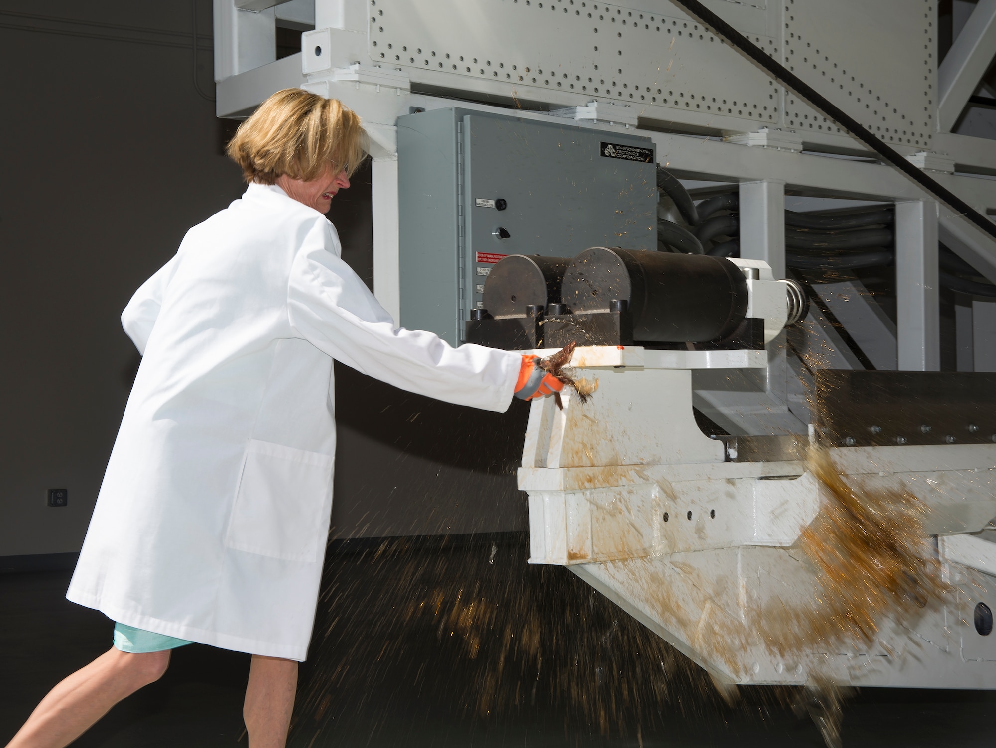 Ann Graybiel christens the disorientation research device, nicknamed “The Kraken”, during the dedication ceremony for the Captain Ashton Graybiel Acceleration Research Facility at Naval Medical Research Unit Dayton, June 17, 2016 on Wright-Patterson Air Force Base, Ohio. Graybiel is the daughter of the facility’s namesake and is an accomplished neuroscientist. (U.S. Air Force photo / R.J. Oriez)