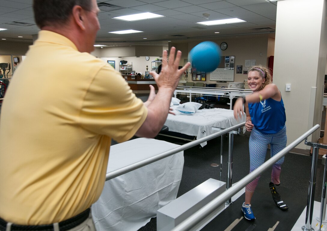 Heather Carter, an above-knee amputee, throws a ball to Bob Bahr, a physical therapist, during a therapy session inside the Military Advanced Training Center at Walter Reed National Military Medical Center in Bethesda, Md., April 13, 2016. Carter, a medically retired senior airman, and other amputees receive physical and occupational therapy at the center as they work toward their goals. One of Carter’s goals is to return to competitive softball. (U.S. Air Force photo/Sean Kimmons)
